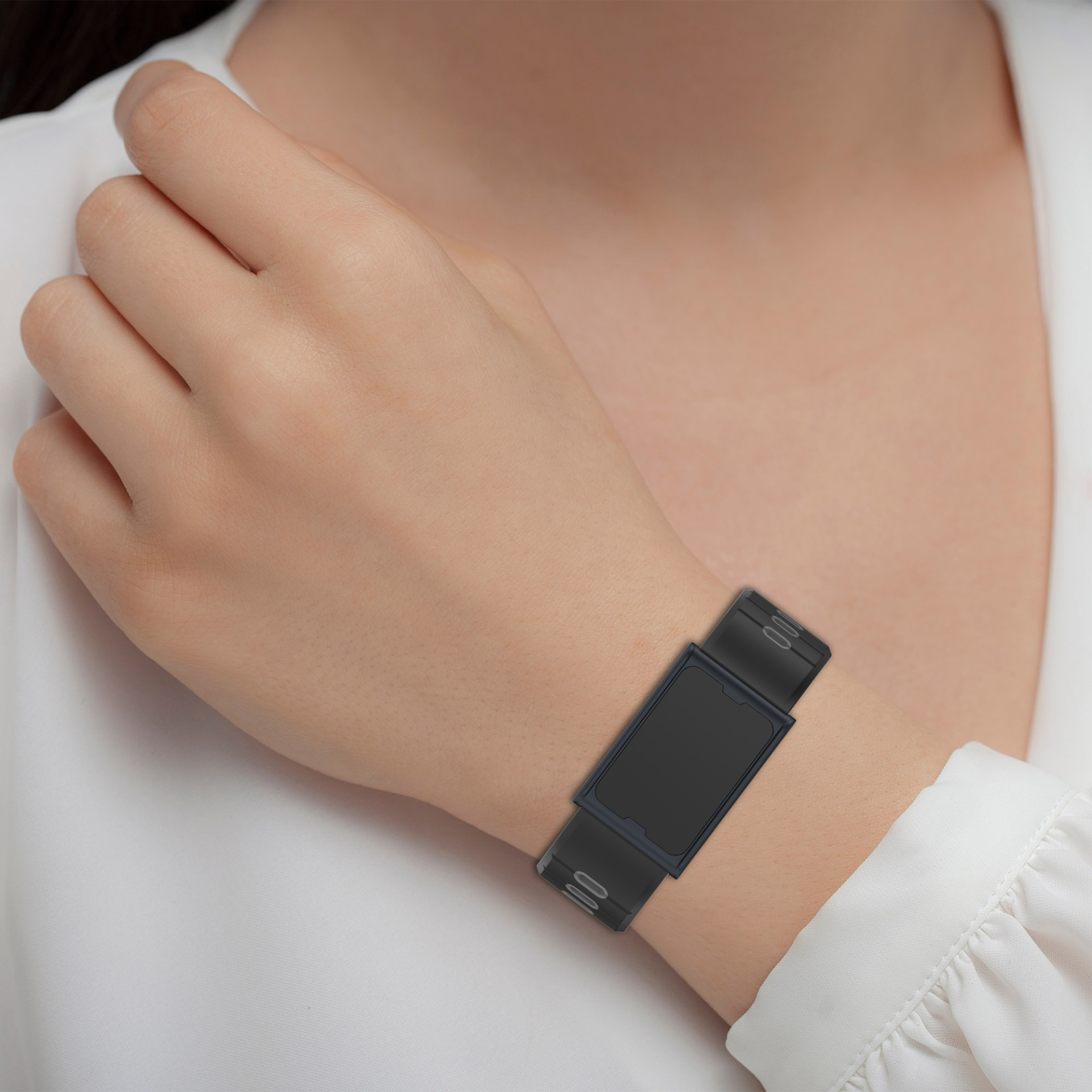 Die Hand einer Person mit einer schwarzen Smartwatch am Handgelenk. Weißes Hemd.