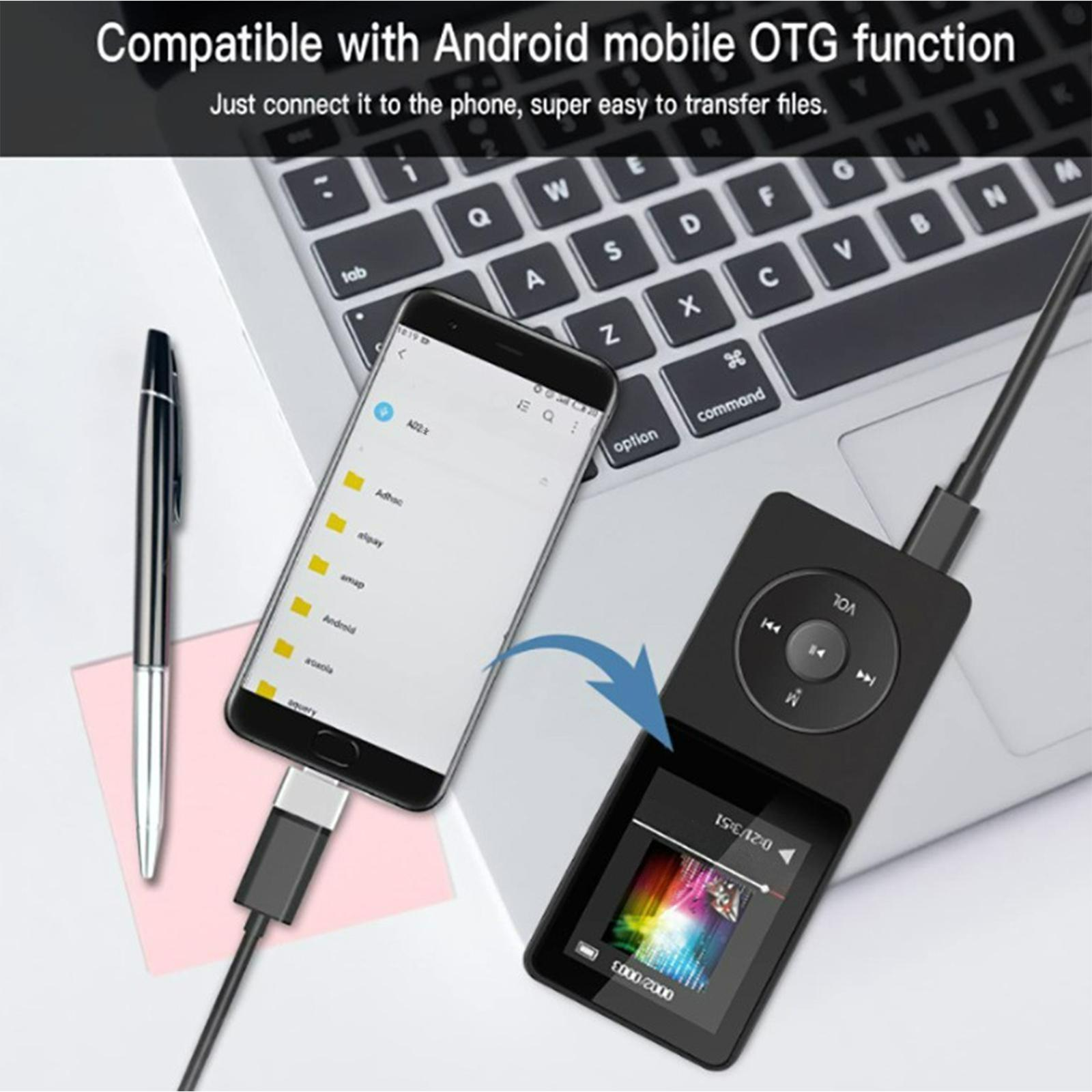 Ein schwarzer MP3-Player ist über ein Kabel mit einem Telefon und einer Laptop-Tastatur verbunden.