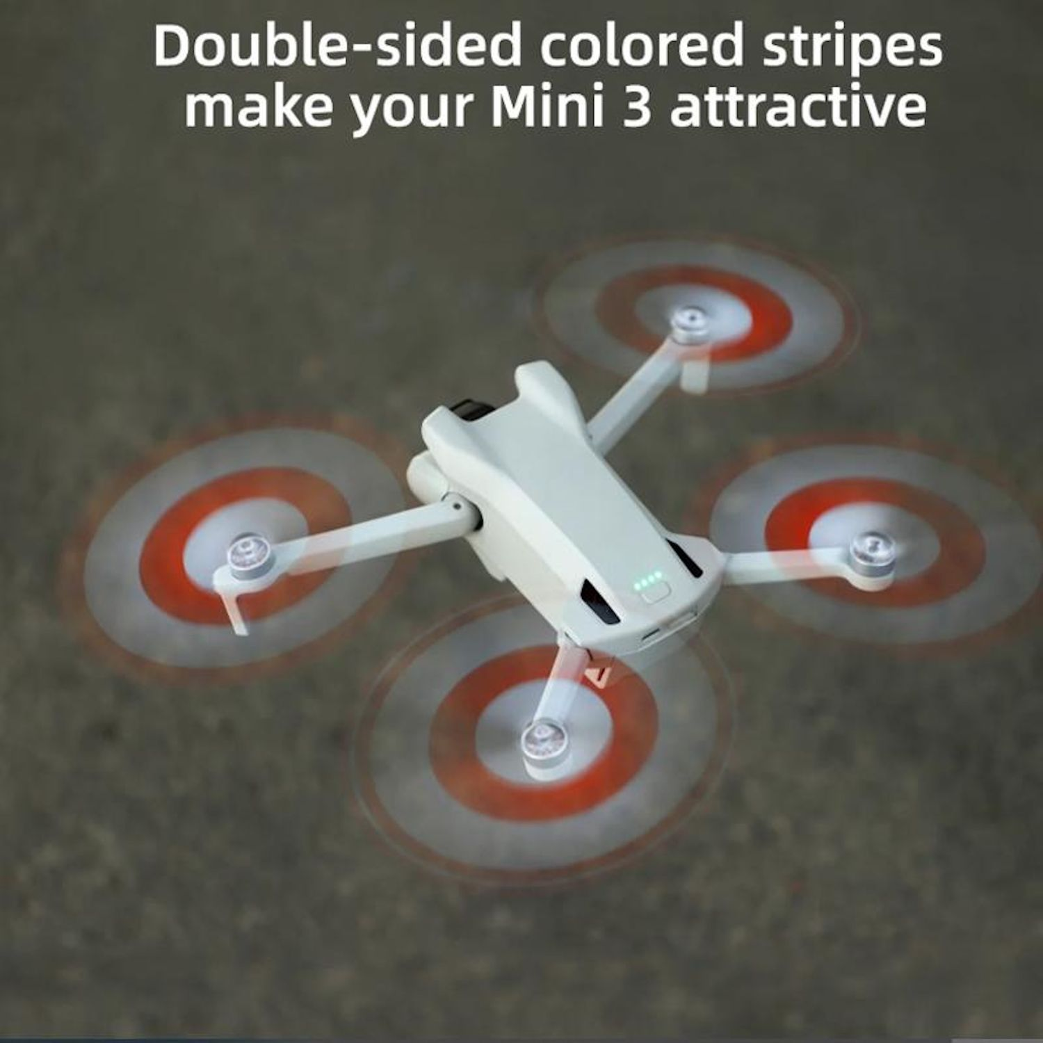 Un drone in aria con eliche rotanti. Le eliche mostrano colori rossi e bianchi. Lo sfondo è sfocato.