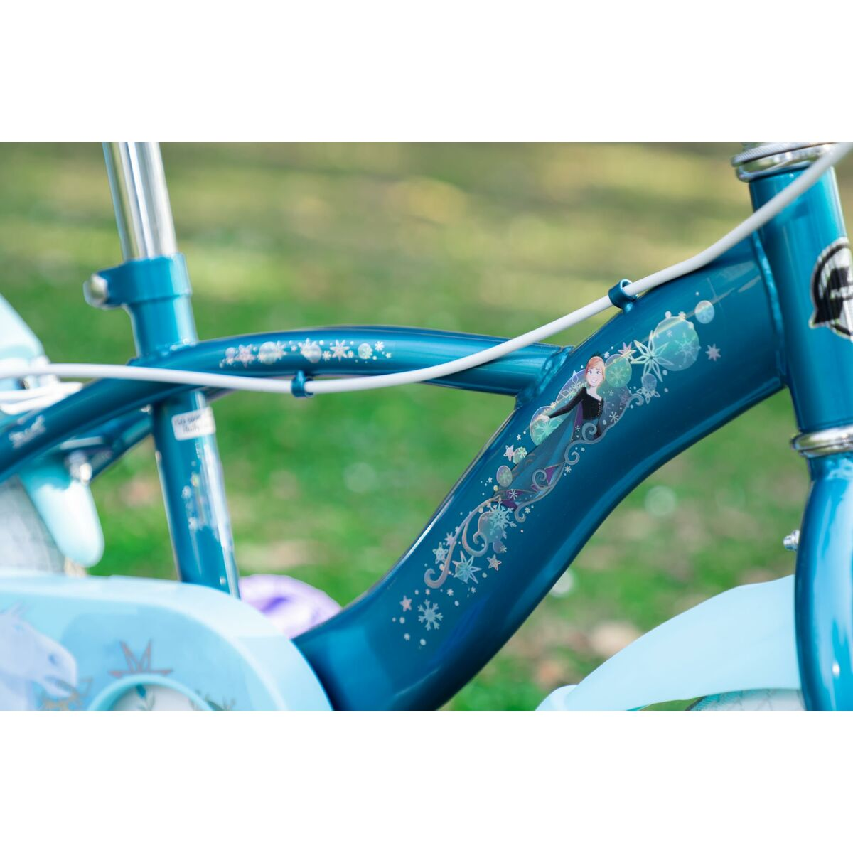 Primo piano del telaio di una bici a tema Frozen. Elsa è raffigurata. La bici è blu e ha dettagli di fiocchi di neve.