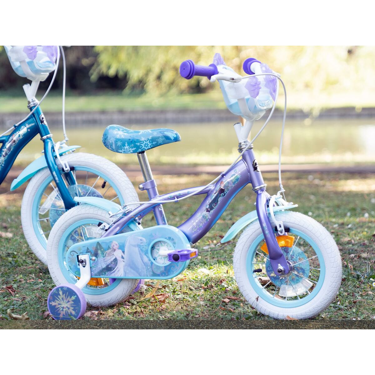 Ein lila Frozen-Fahrrad mit weißen Reifen. Elsa- und Anna-Grafiken sind abgebildet. Ein weiteres Frozen-Fahrrad ist dahinter.