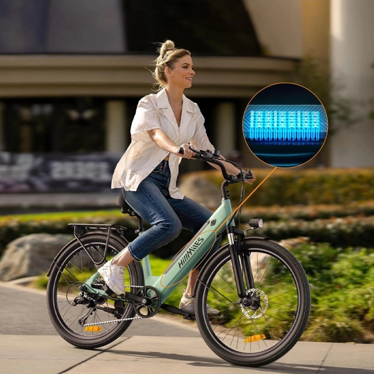 Una donna guida una bici elettrica verde menta. Un primo piano mostra un display digitale con luci blu.