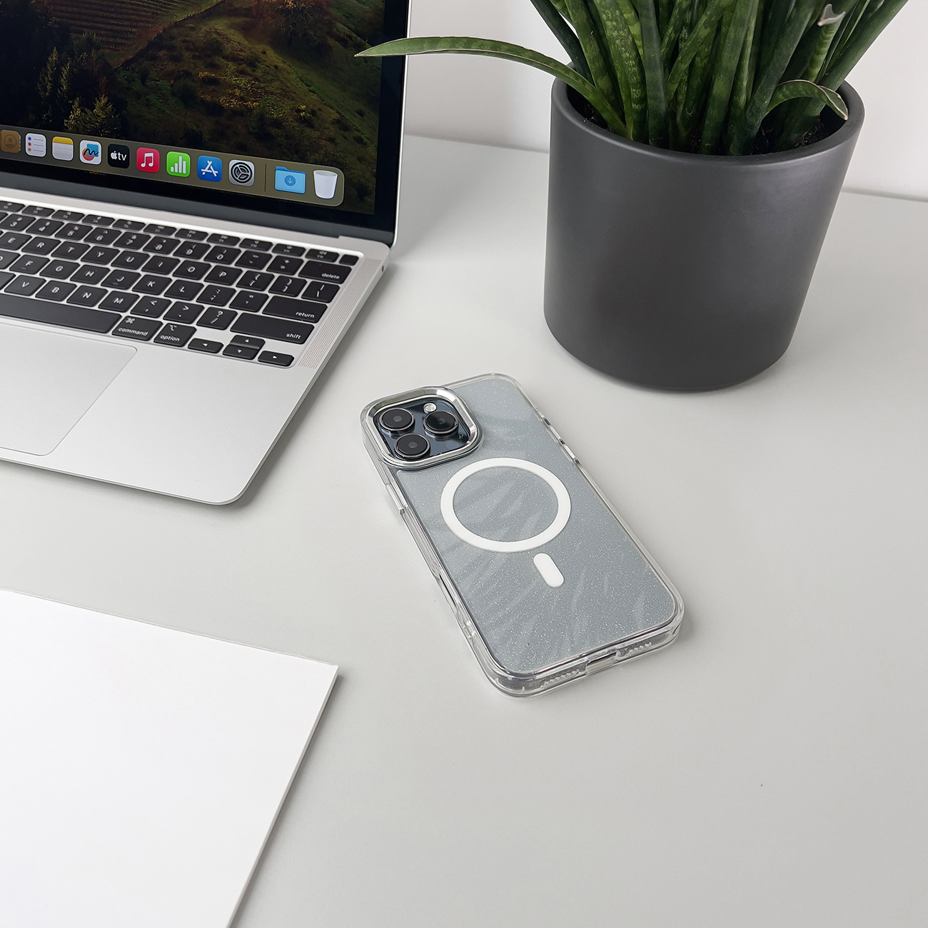 Etui na telefon na biurku z laptopem i rośliną, widok z góry, pokazujący design etui.