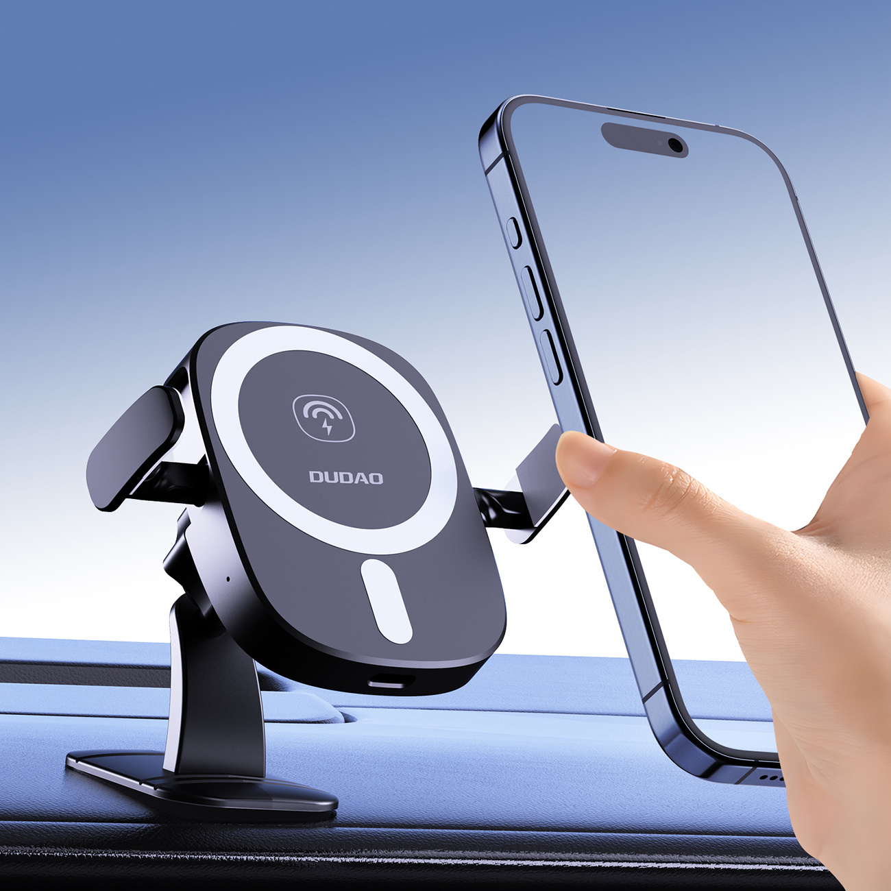 Ręka umieszcza telefon na czarnym uchwycie na telefon. Uchwyt znajduje się na desce rozdzielczej samochodu. Niebieskie niebo w tle.