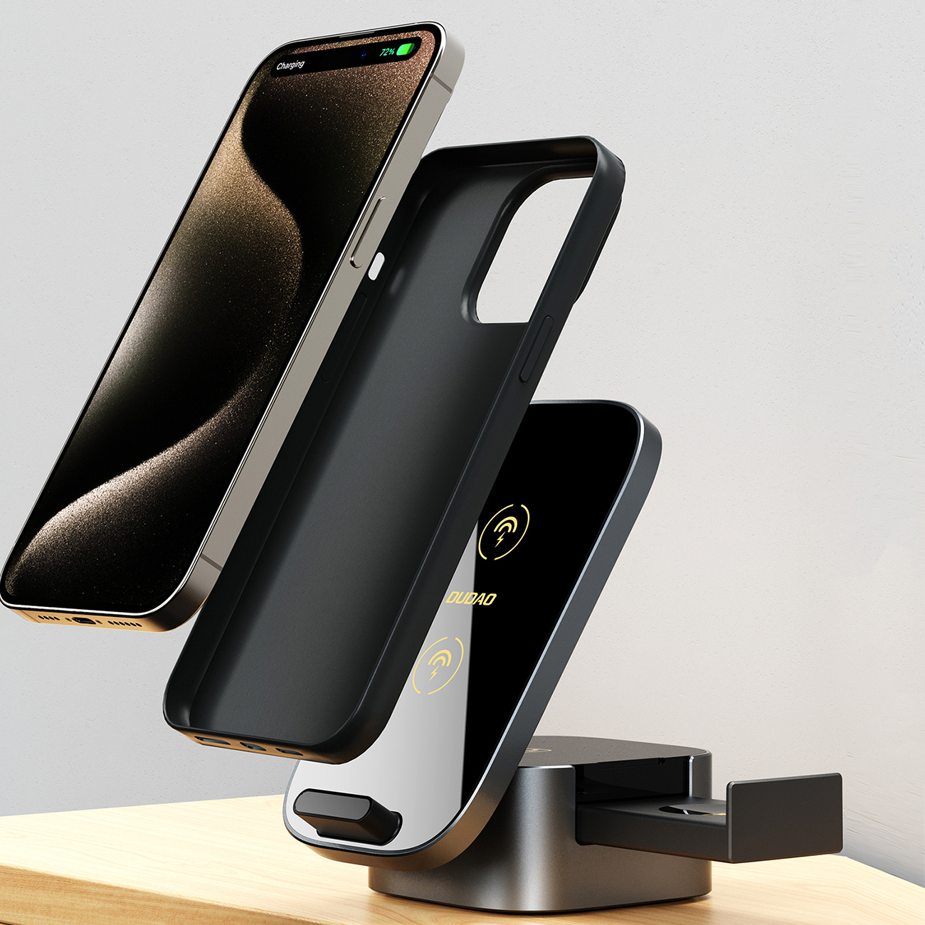 Telefon, jego etui i stojak do ładowania na drewnianej powierzchni.