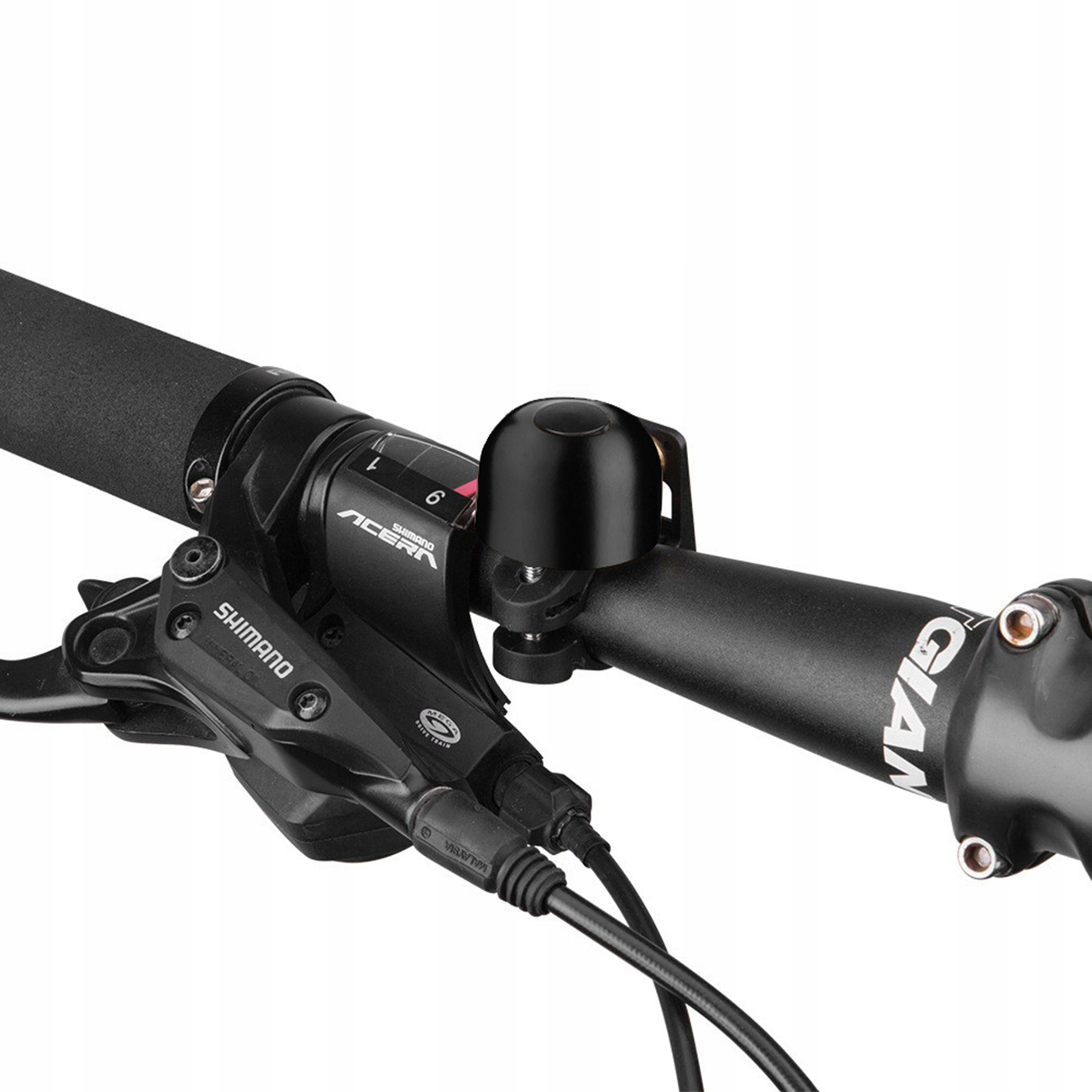 Kierownica roweru z przymocowanym czarnym dzwonkiem. Rower ma hamulce i przerzutki Shimano.