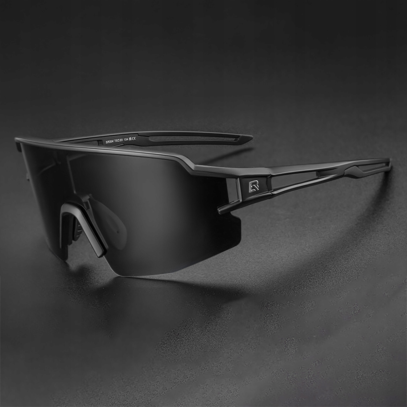 Occhiali da sole neri su una superficie scura. Gli occhiali hanno un design moderno e sportivo.