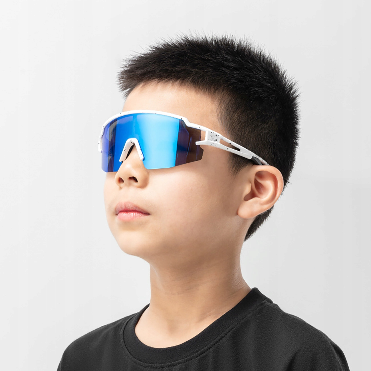 Un ragazzo con occhiali da sole sportivi bianchi con lenti blu riflettenti, maglietta nera.
