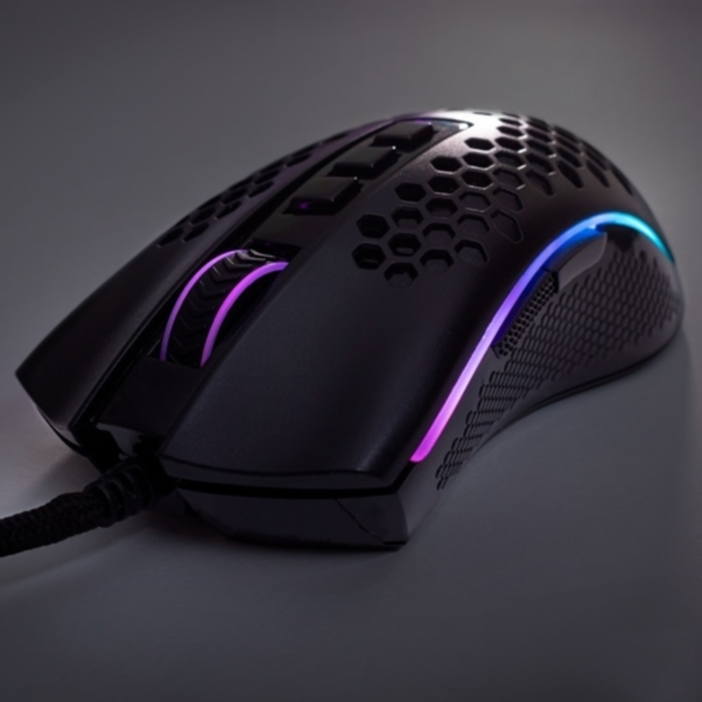 Czarna mysz do gier z wzorem plastra miodu, podświetleniem RGB, na szarej powierzchni, zbliżenie.