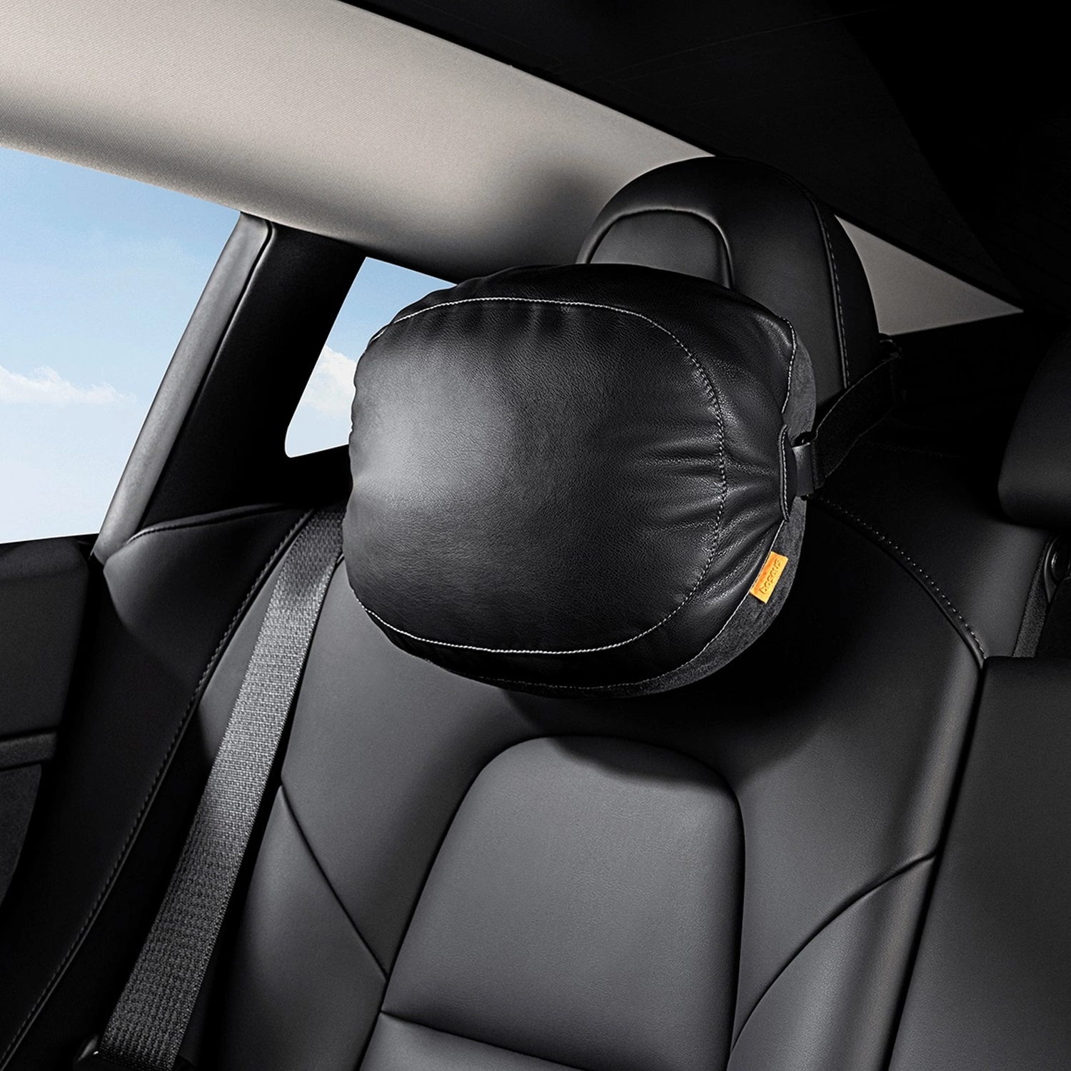 Czarny zagłówek samochodowy z czarną poduszką. Posiada żółtą metkę i białe szwy.