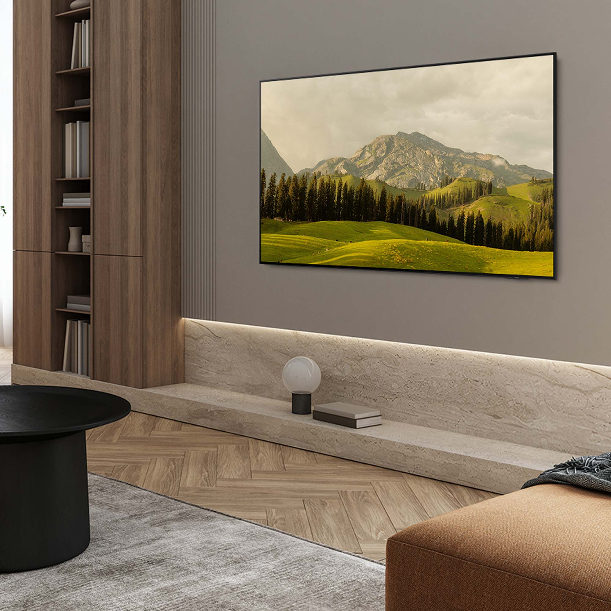 Ujęcie wnętrza salonu z telewizorem pokazującym krajobraz, nad długą beżową ławką.
