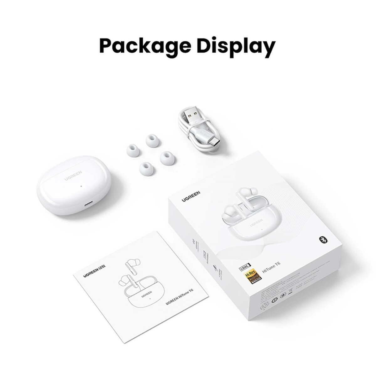 Wyświetlacz opakowania słuchawek UGREEN z akcesoriami: etui ładujące, wkładki douszne, kabel do ładowania i instrukcja.