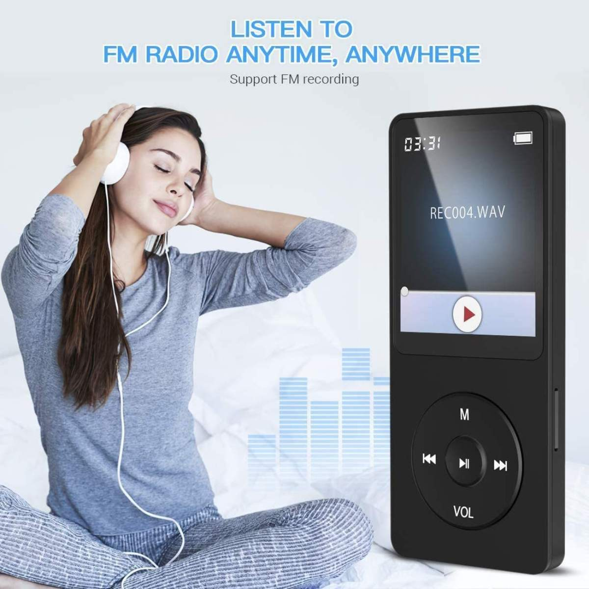 Frau hört Musik mit Kopfhörern, neben einem MP3-Player, auf einem Bett.