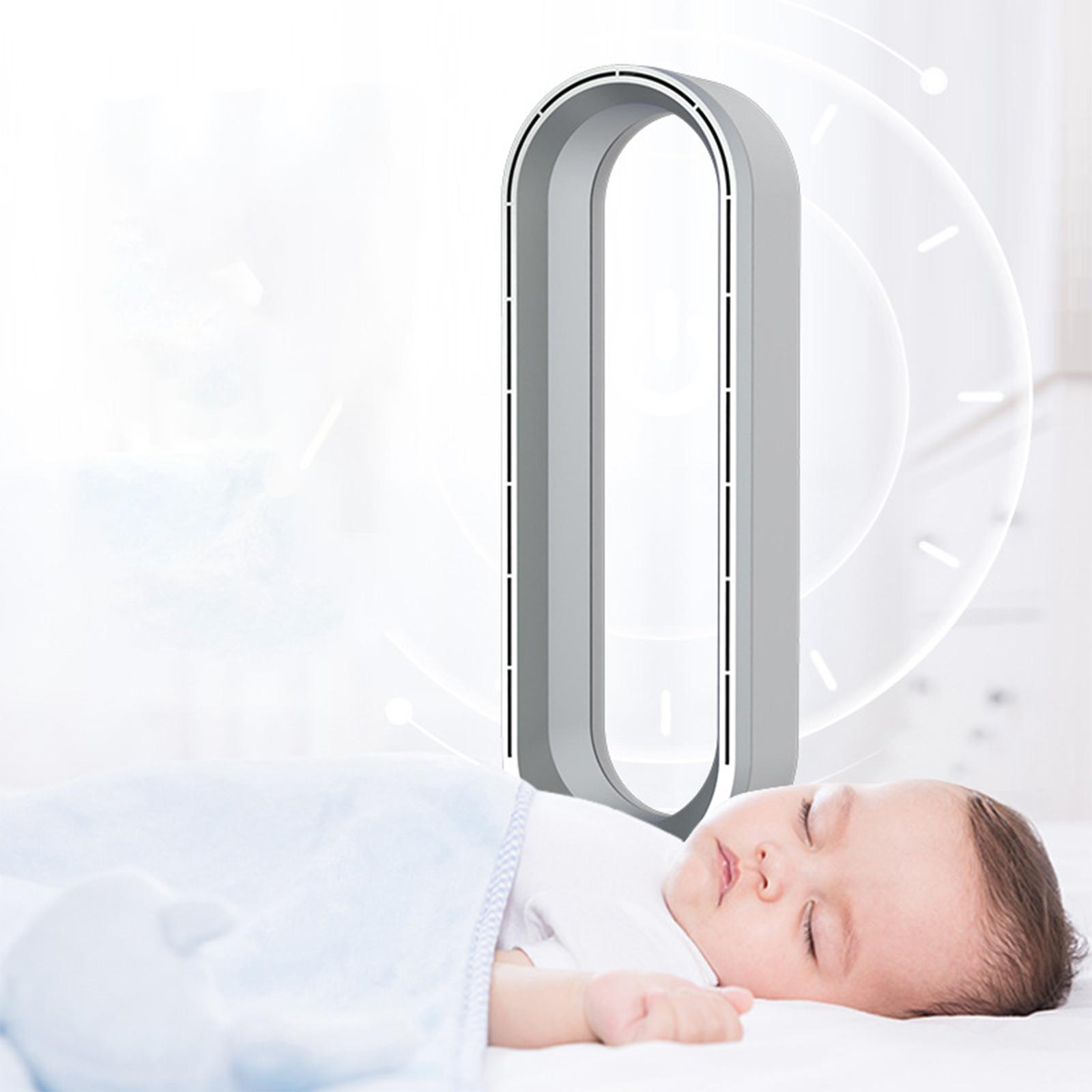 Ein weiß-grauer Luftreiniger mit einem schlafenden Baby im Vordergrund unter einer blauen Decke.