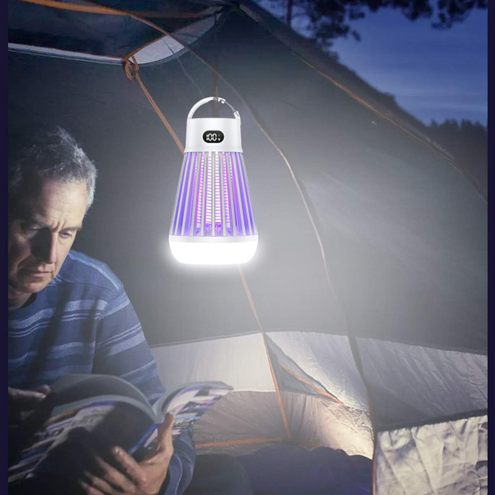 Mann liest in einem Zelt mit einem Insektenvernichter. Der Zapper hat eine Digitalanzeige und violettes Licht, das das Zelt beleuchtet.