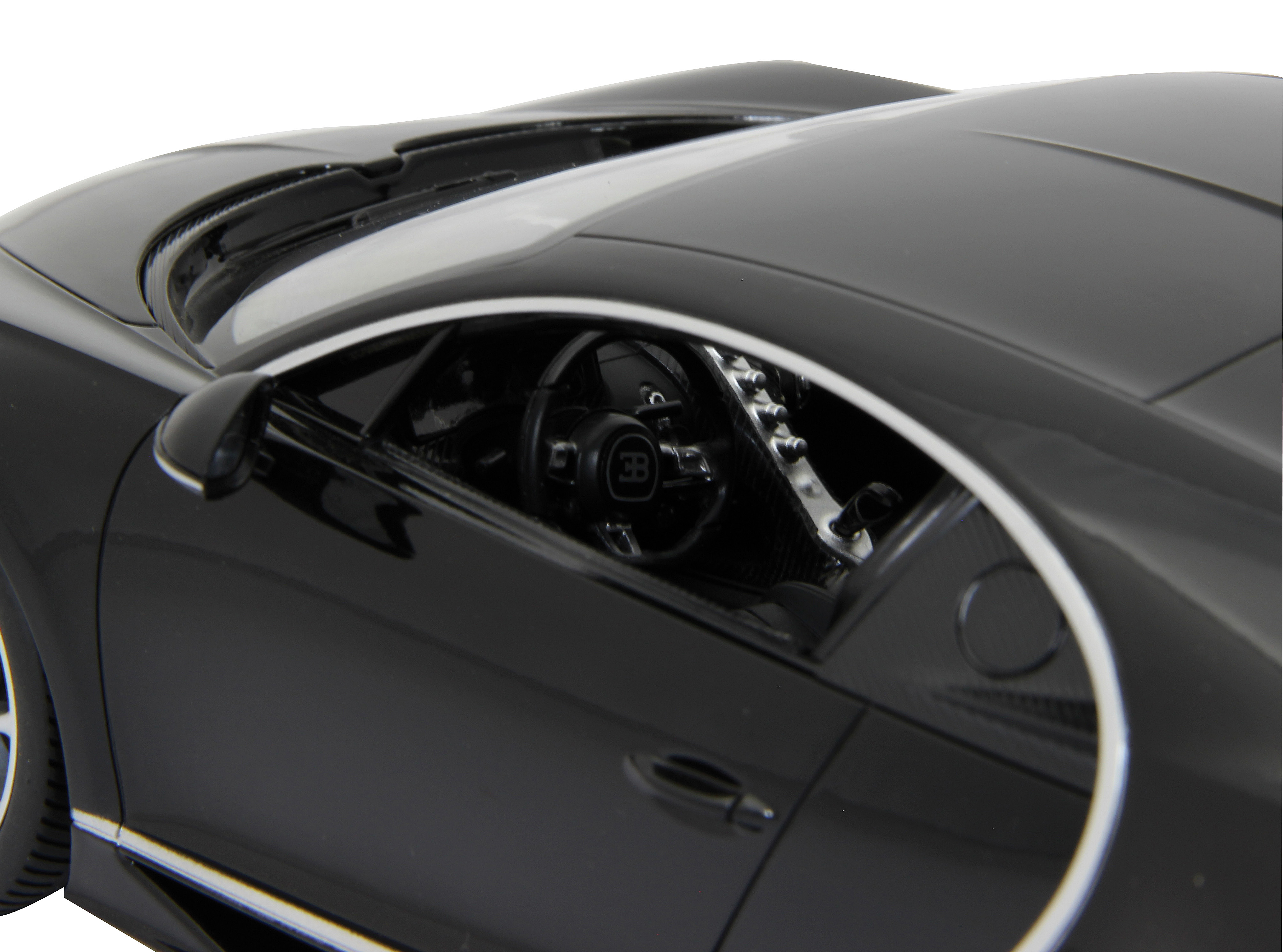 Nahaufnahme der Innenausstattung eines schwarzen Bugatti Chiron Modellautos. Lenkrad und Armaturenbrett sind sichtbar.