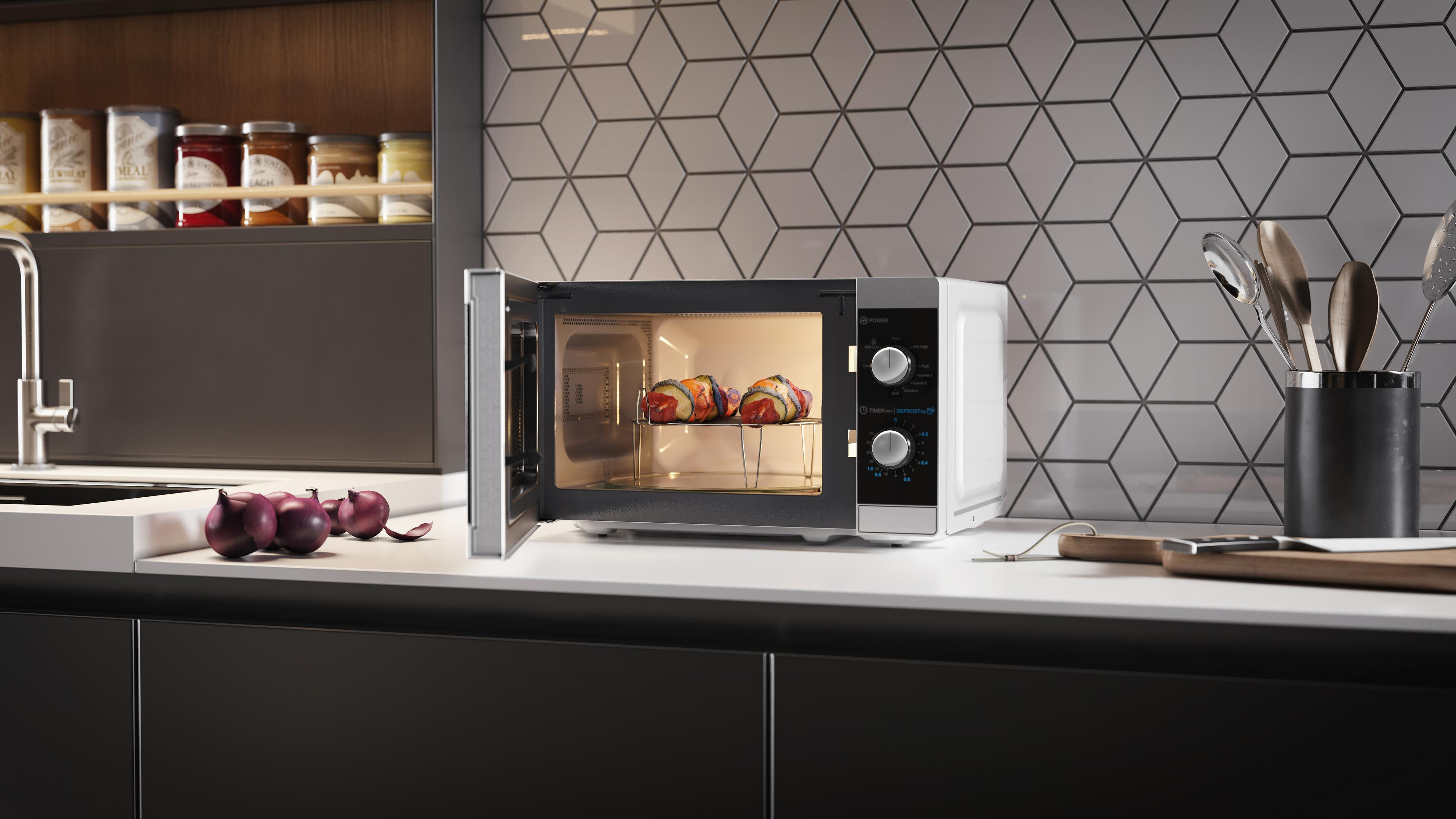 Kuchenka mikrofalowa z jedzeniem w środku, otwarta w kuchni. Cebula na blacie obok.