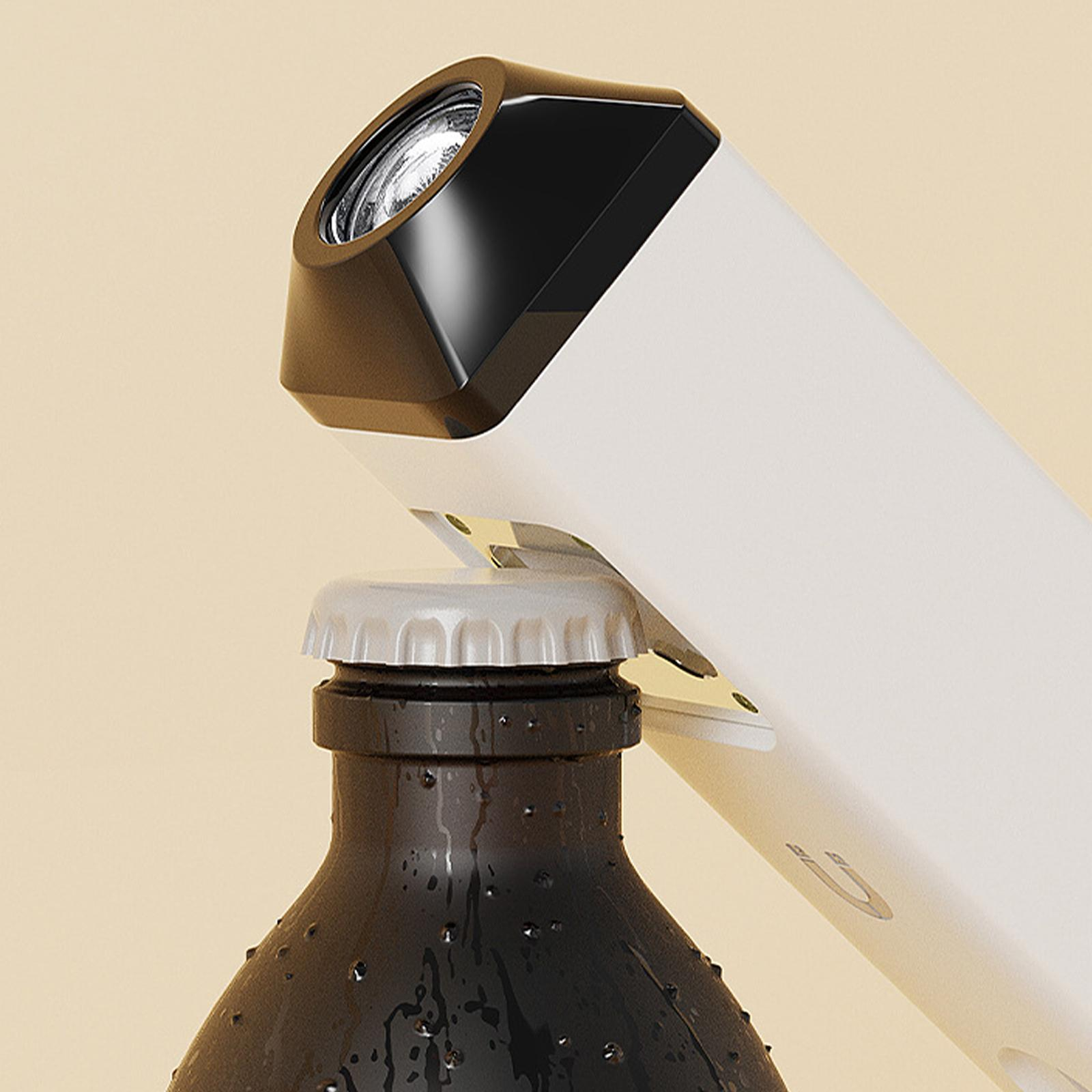 Weißer und schwarzer Öffner öffnet eine braune Flasche. Der Flaschenverschluss ist grau und glänzend.