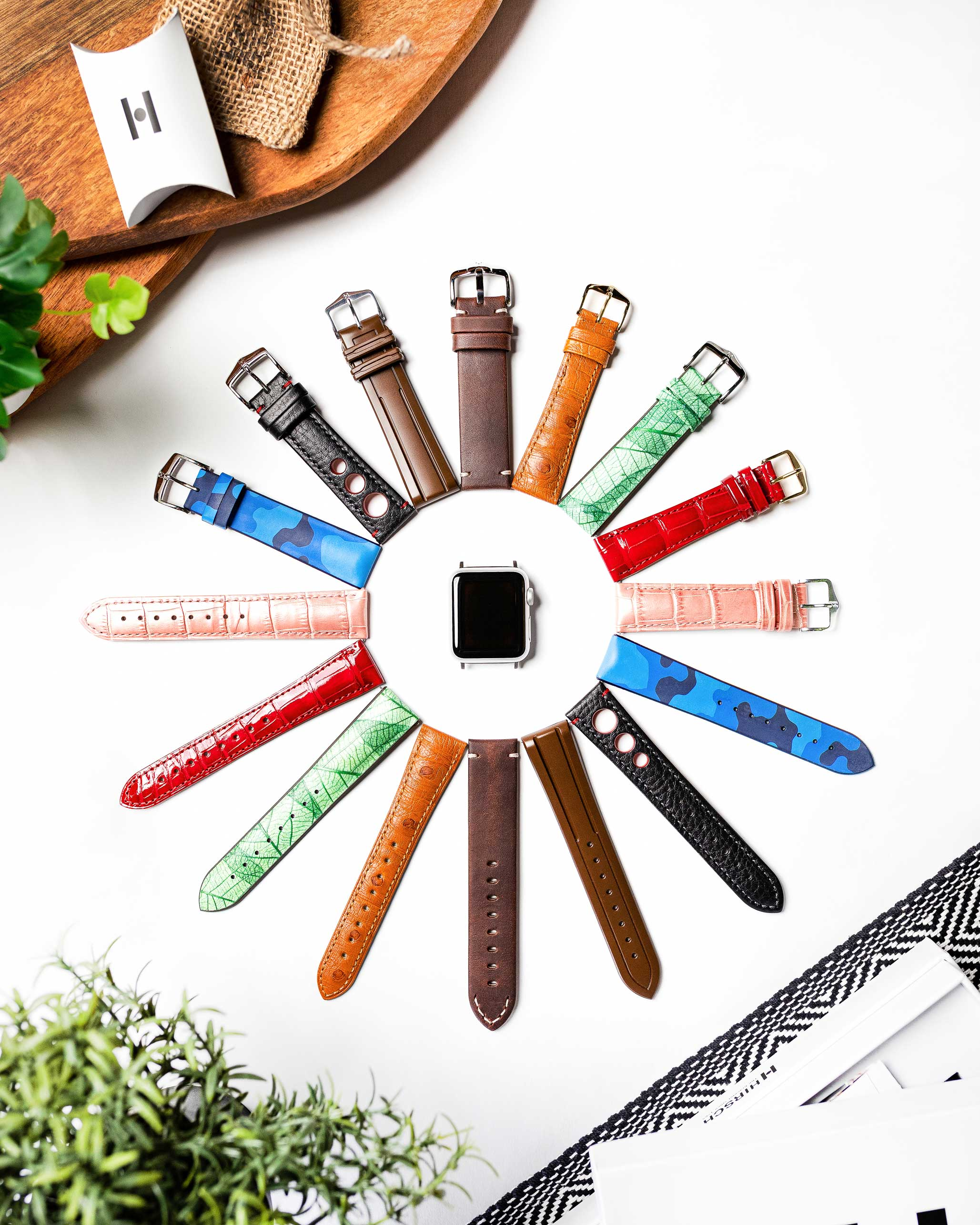 Eine Sammlung von Uhrenarmbändern in verschiedenen Farben und Mustern, um eine Uhr angeordnet.