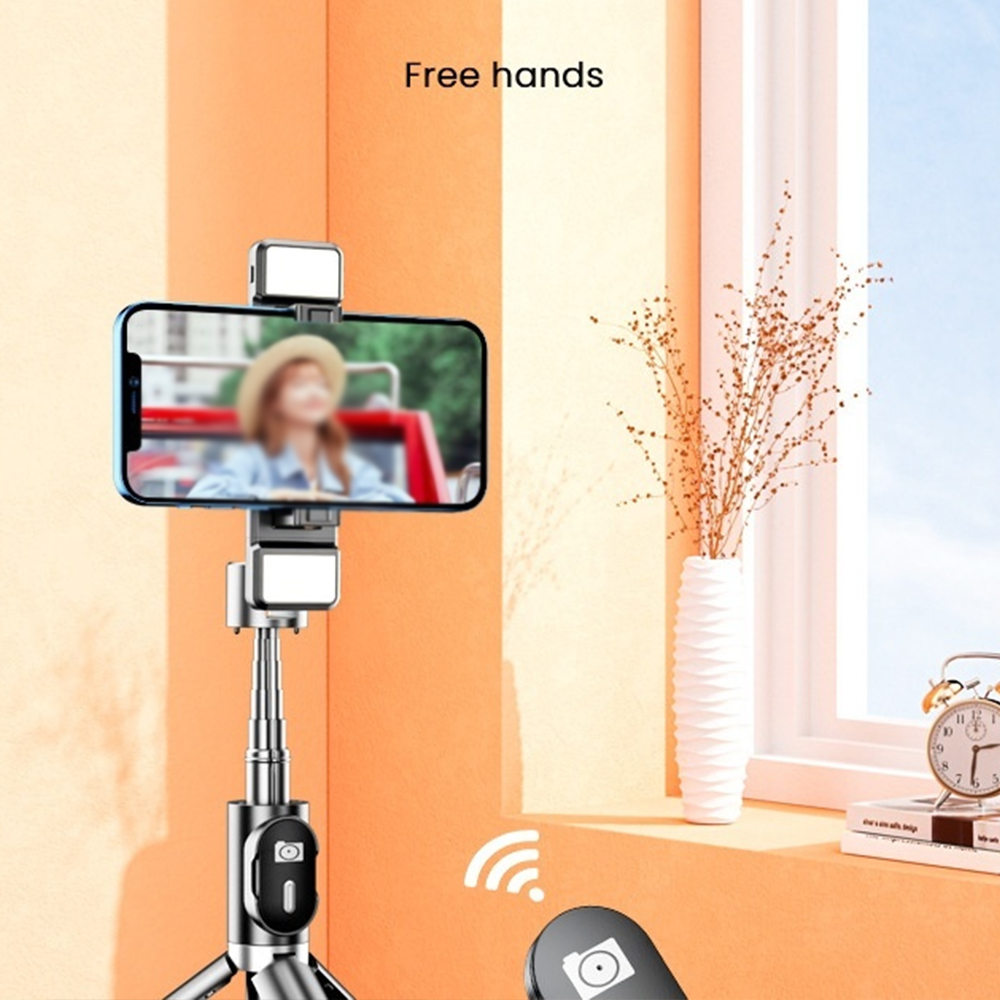 Ein silberner Selfie-Stick mit einem Telefon, das eine Person anzeigt. Eine Fernbedienung ist im Vordergrund.