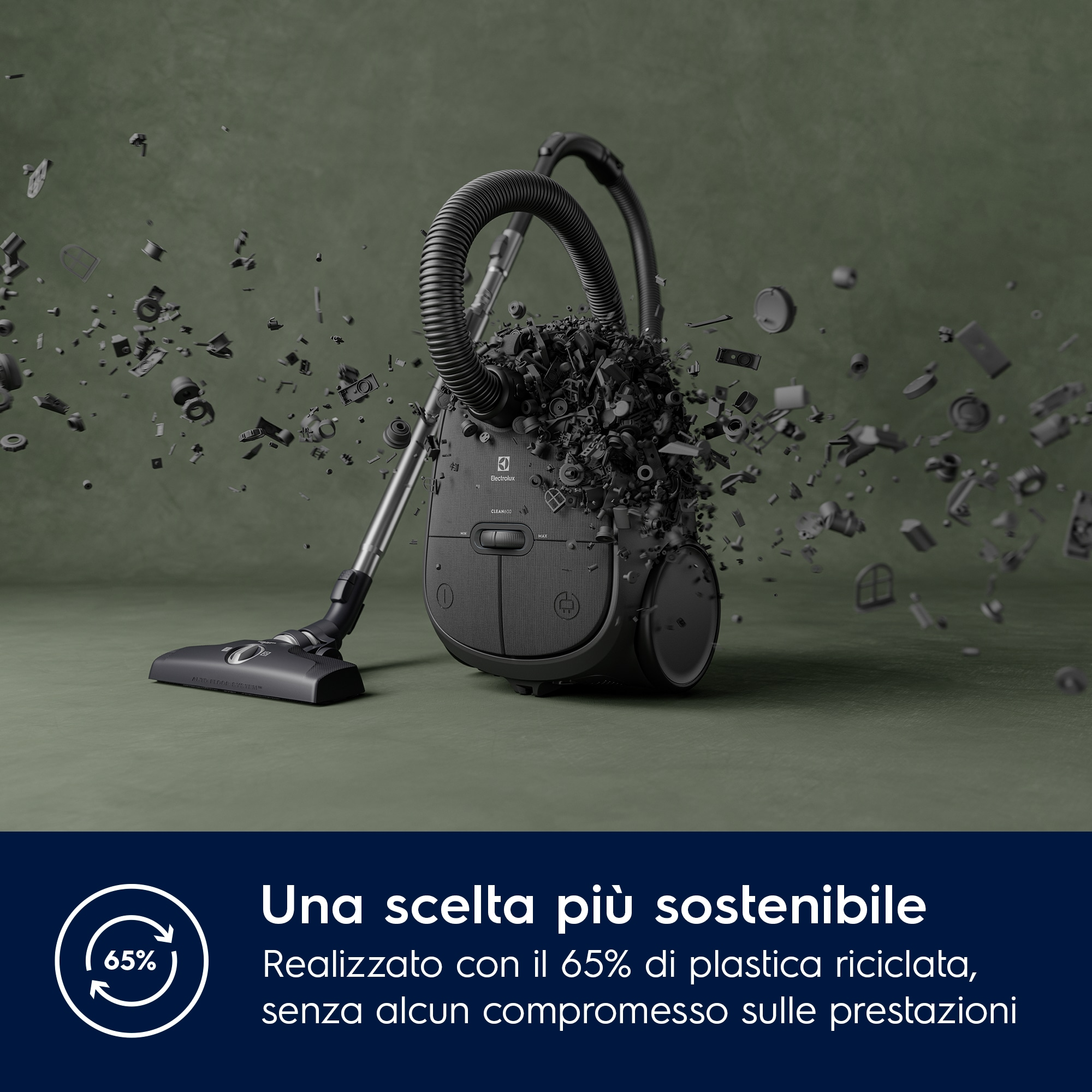 Aspirapolvere nero con detriti che esplodono intorno. Il testo indica che è realizzato con il 65% di plastica riciclata.