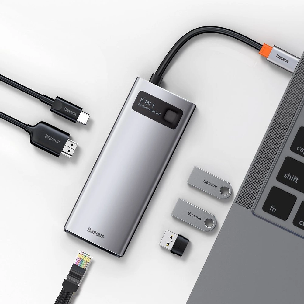 Srebrny hub z kablami, napędami USB i laptopem. Hub ma wiele portów i nazwę marki.