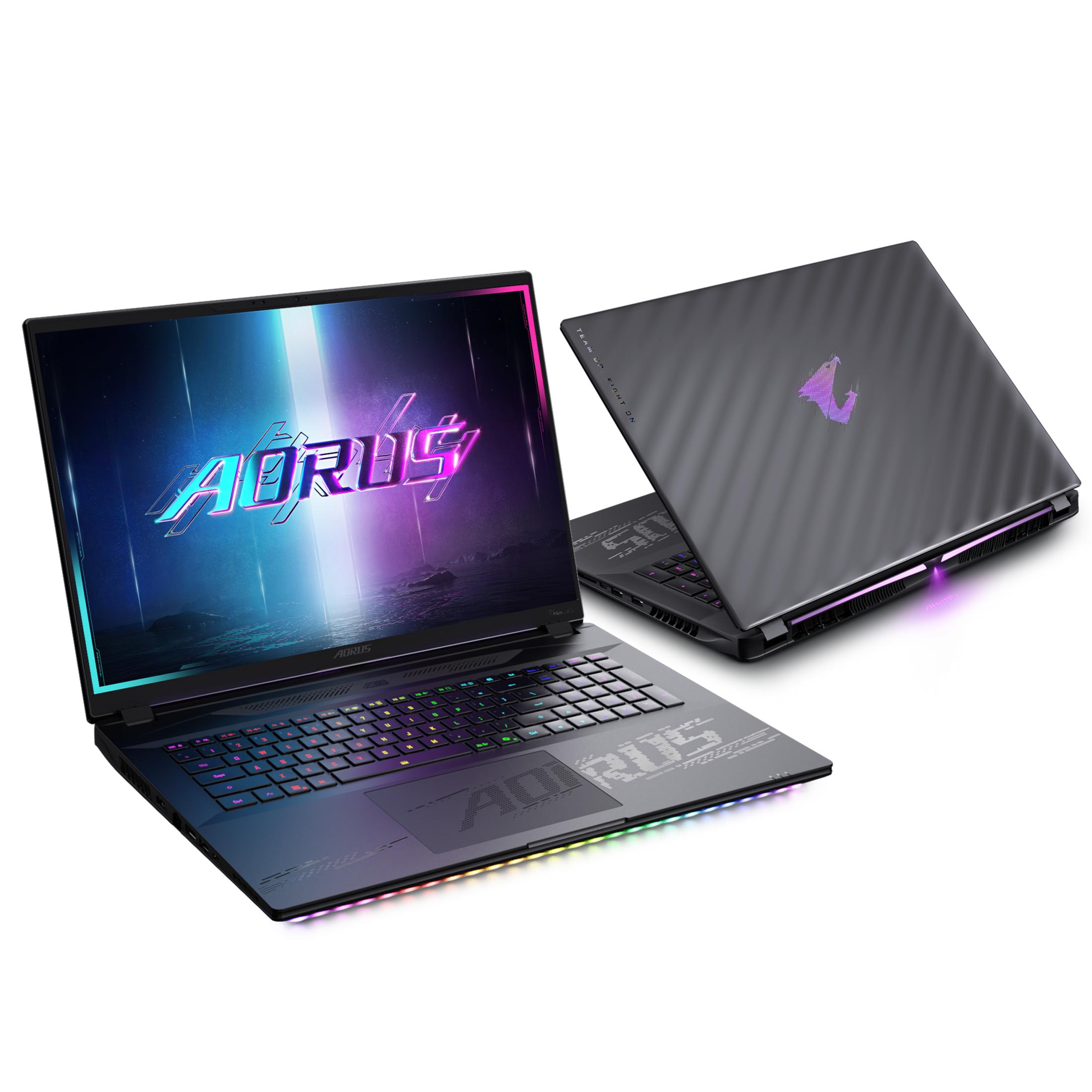 Schwarzer AORUS-Laptop mit offenem Bildschirm, der Grafiken zeigt, ein zweiter Laptop dahinter. Die Tastatur leuchtet.