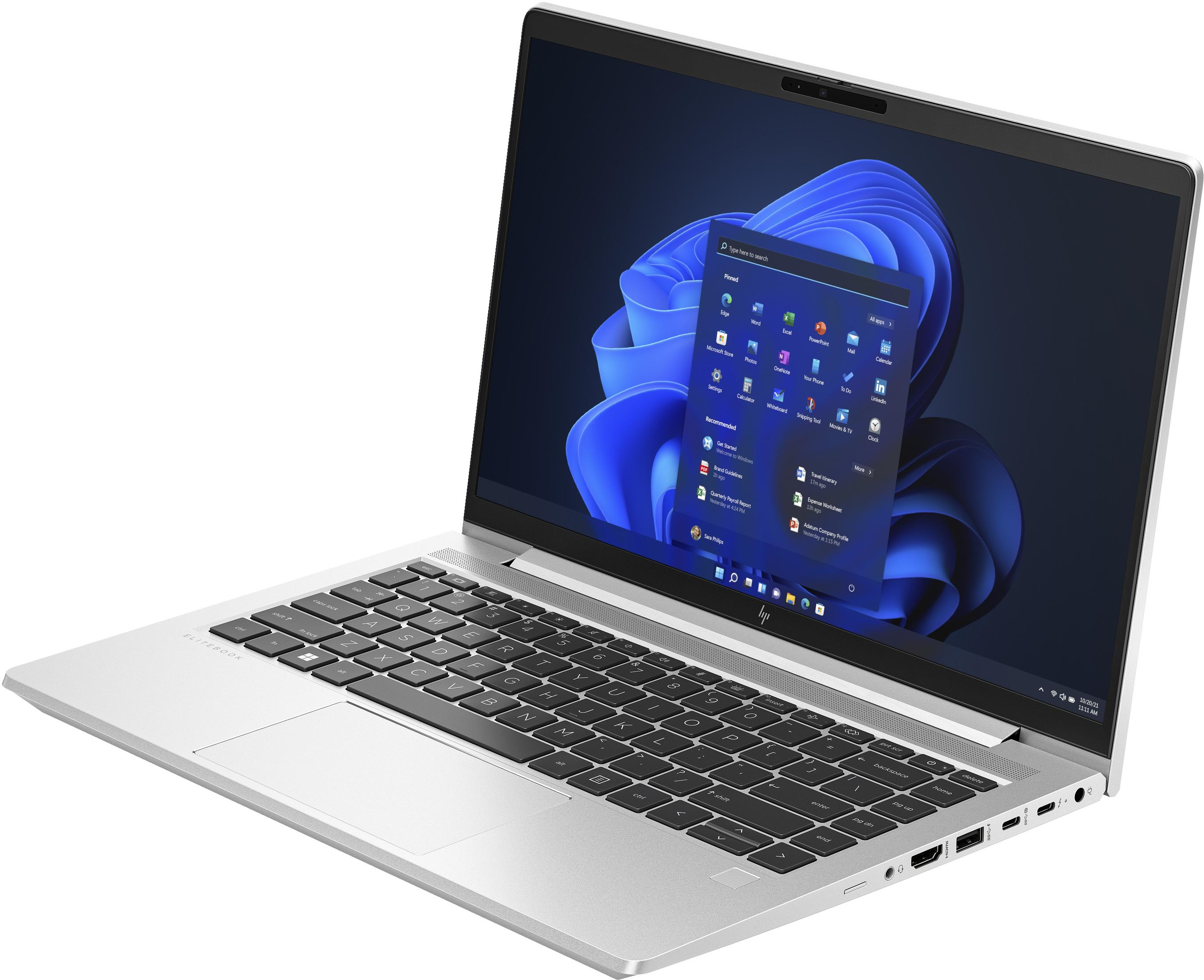 Srebrny laptop otwarty, pokazujący interfejs Windows 11. Białe tło. Widok z boku laptopa.