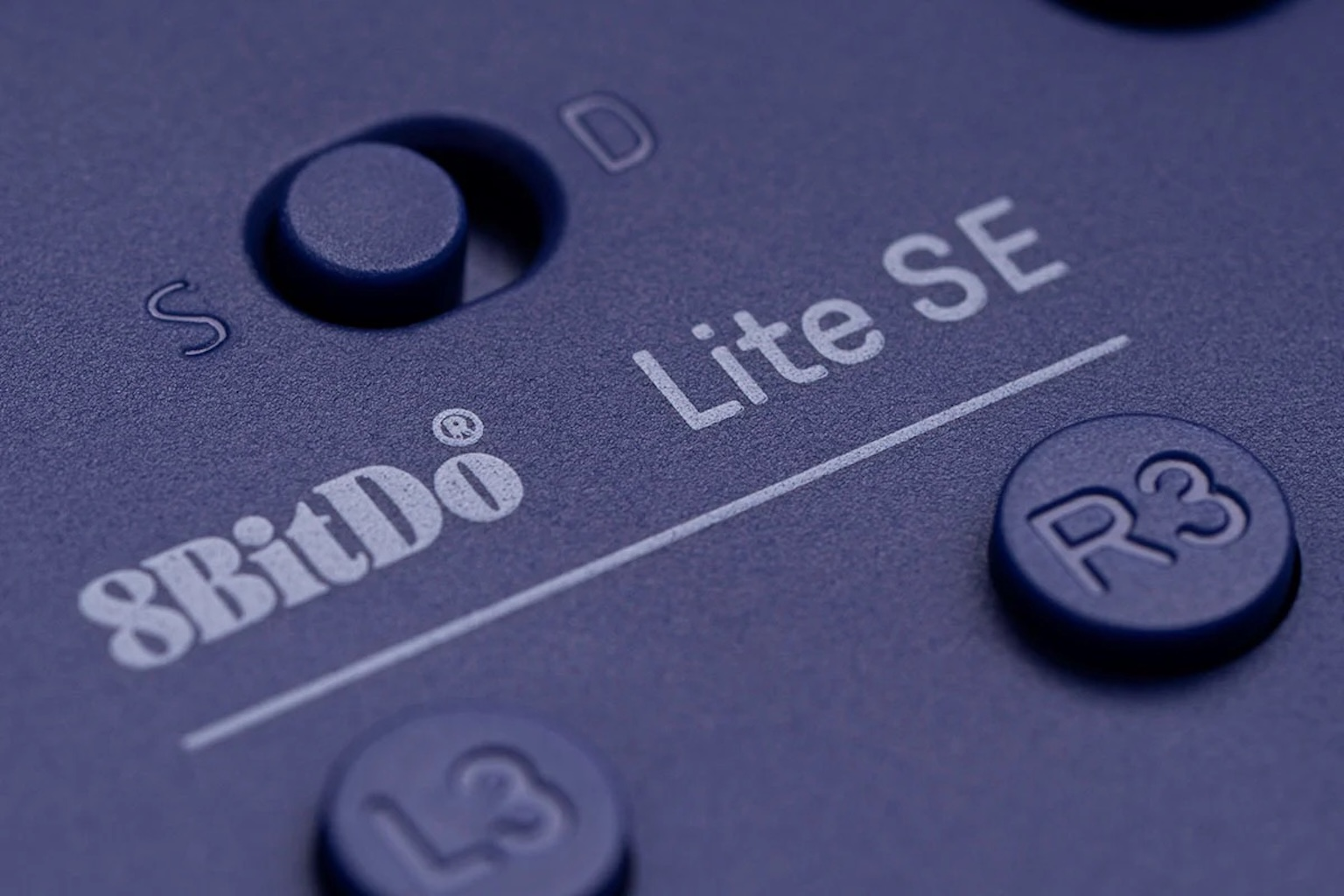 Primo piano del controller con i pulsanti: 8BitDo Lite SE, S, D, R3 e L3. Superficie blu con testo bianco stampato.