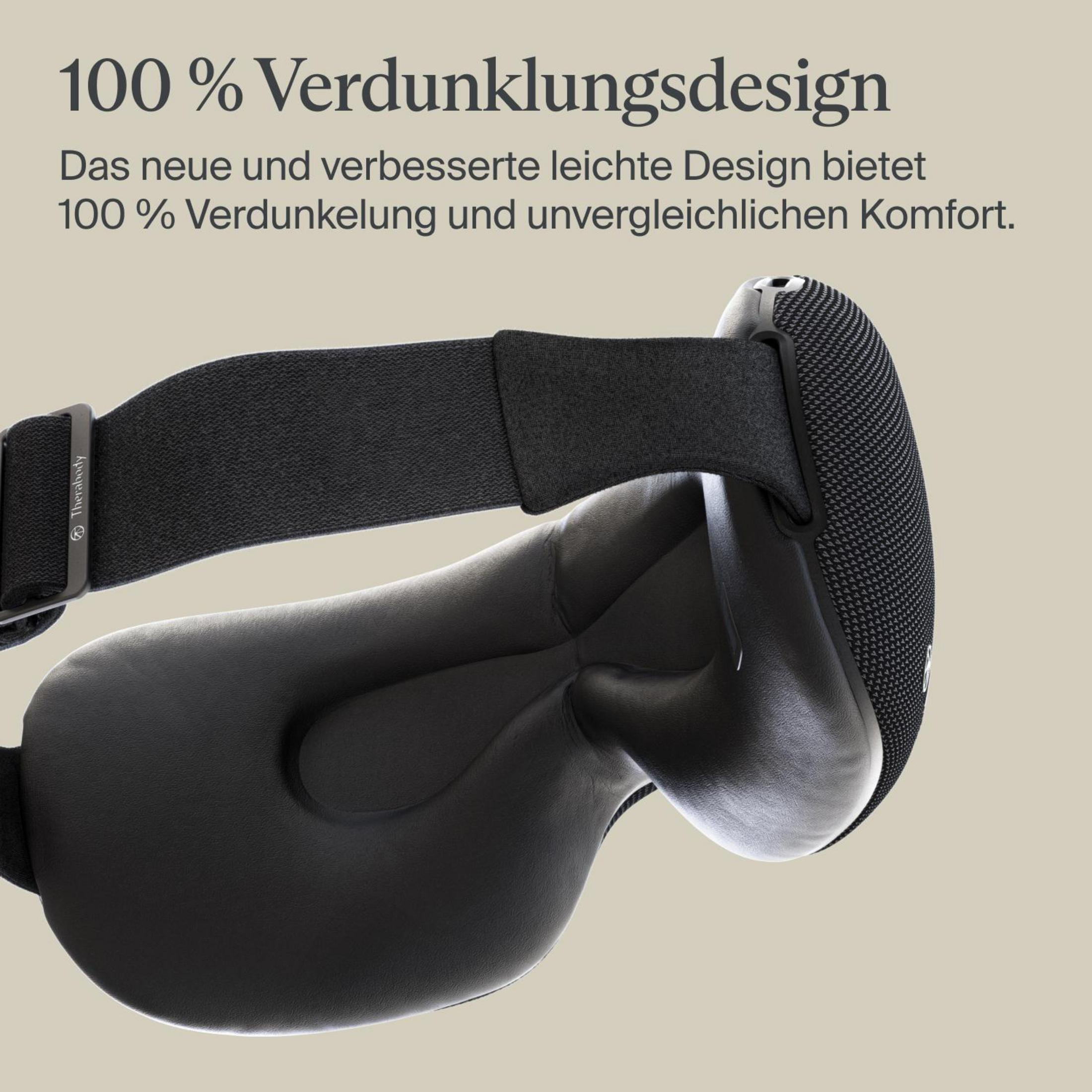 Máscara de ojos negra con texto en alemán: '100% Verdunklungsdesign'. La máscara está sobre una superficie clara.