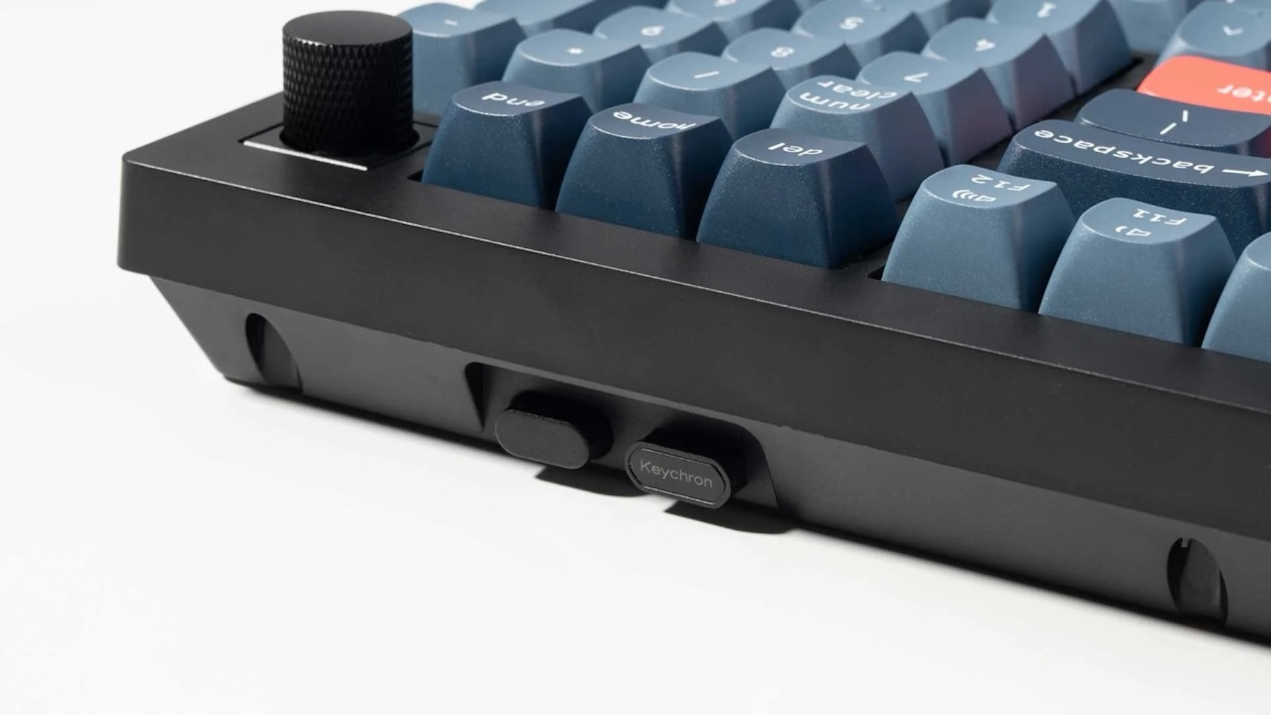 Zbliżenie czarnej klawiatury z niebieskimi klawiszami i czerwonym klawiszem Enter. Marka Keychron.