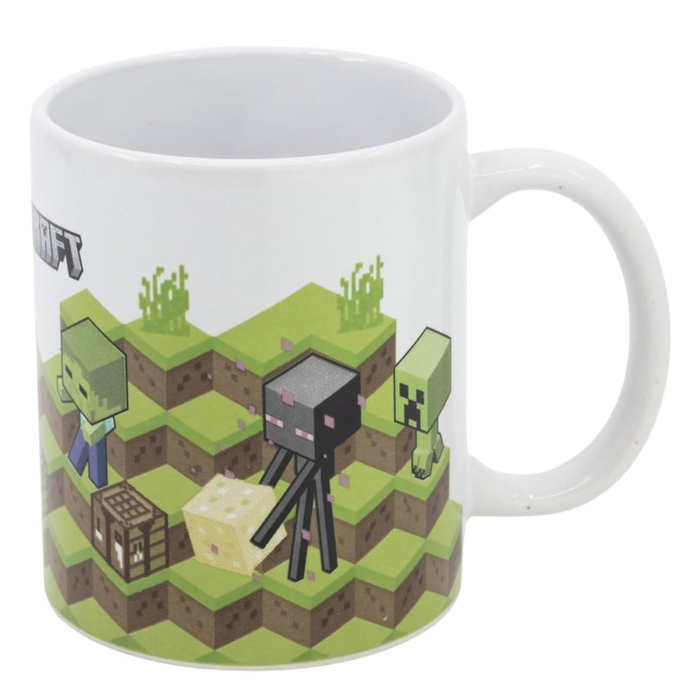 Una tazza di Minecraft con personaggi di Minecraft. La tazza è bianca con erba verde e un logo di Minecraft.