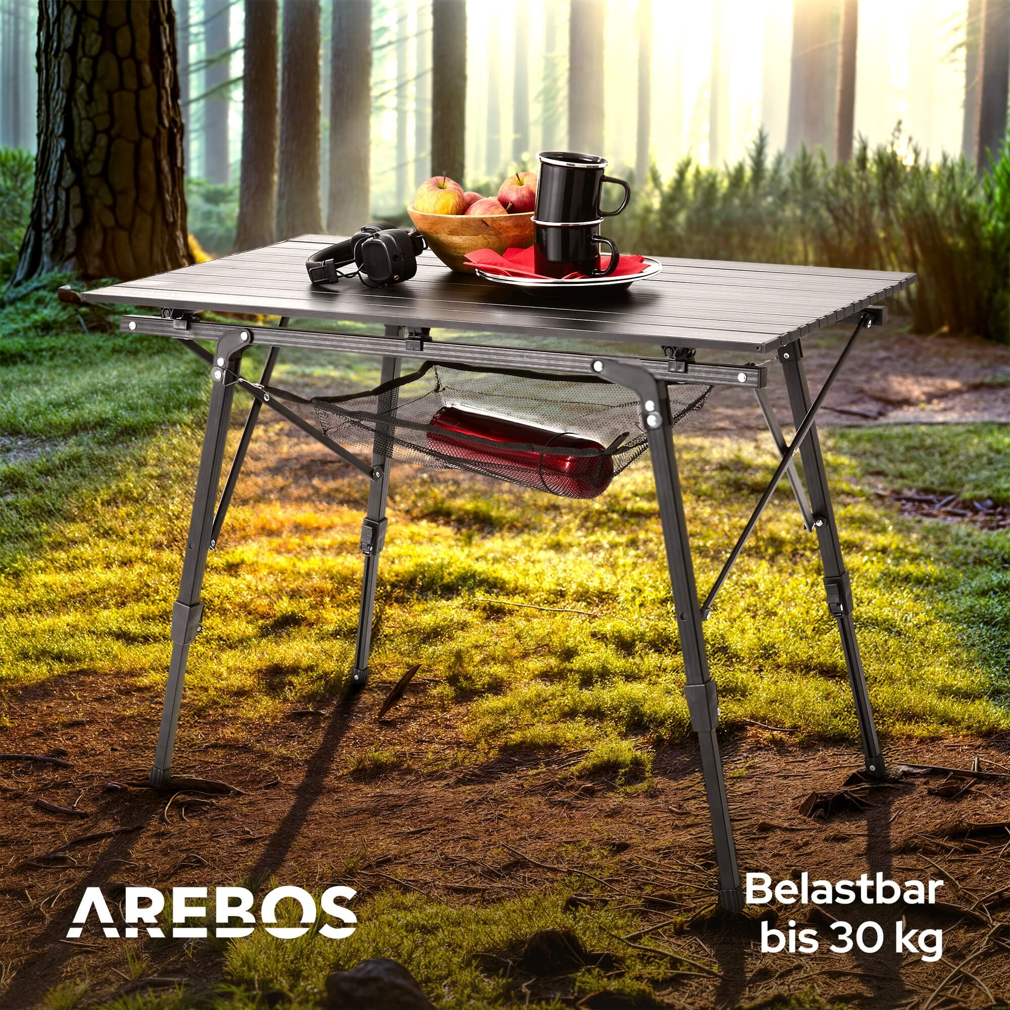 Klapptisch im Wald aufgebaut. Auf dem Tisch sind Früchte und Getränke. Der Tisch ist schwarz.