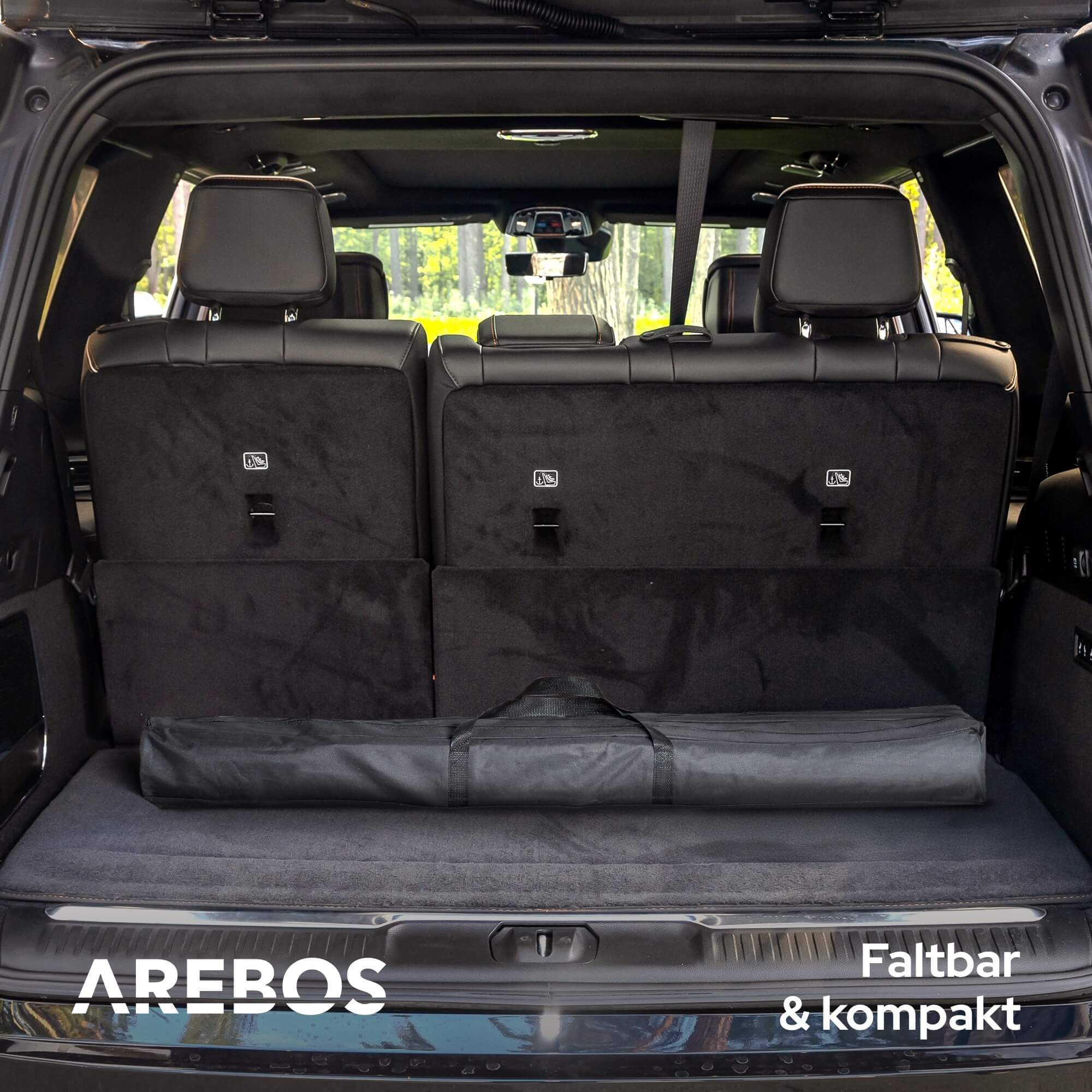 Offener Kofferraum, schwarzer Innenraum. Ein gefalteter schwarzer Gegenstand liegt auf dem Boden, AREBOS.