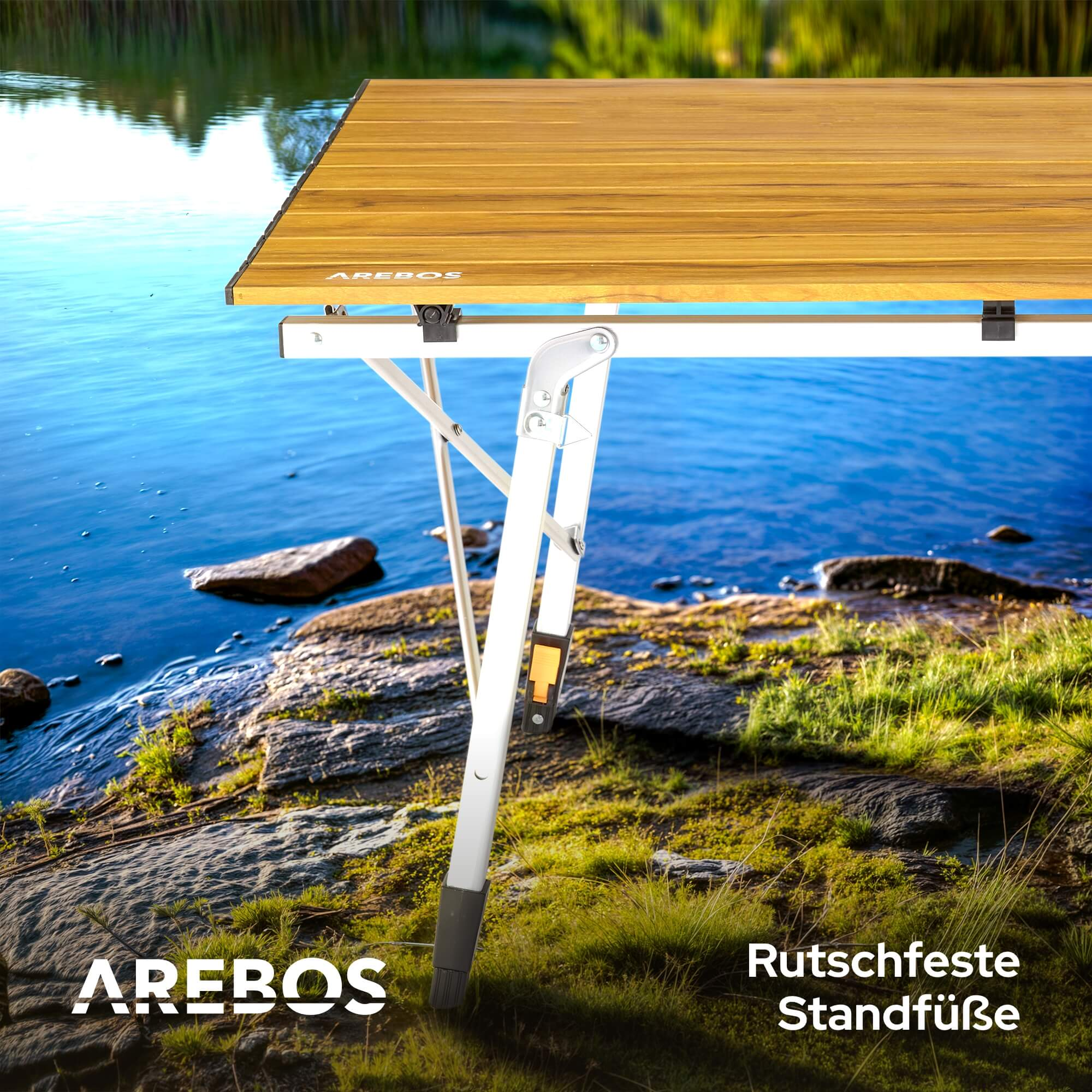 Klapptisch an einem See. Ein Teil des Tischbeins ist hervorgehoben, AREBOS Logo sichtbar.