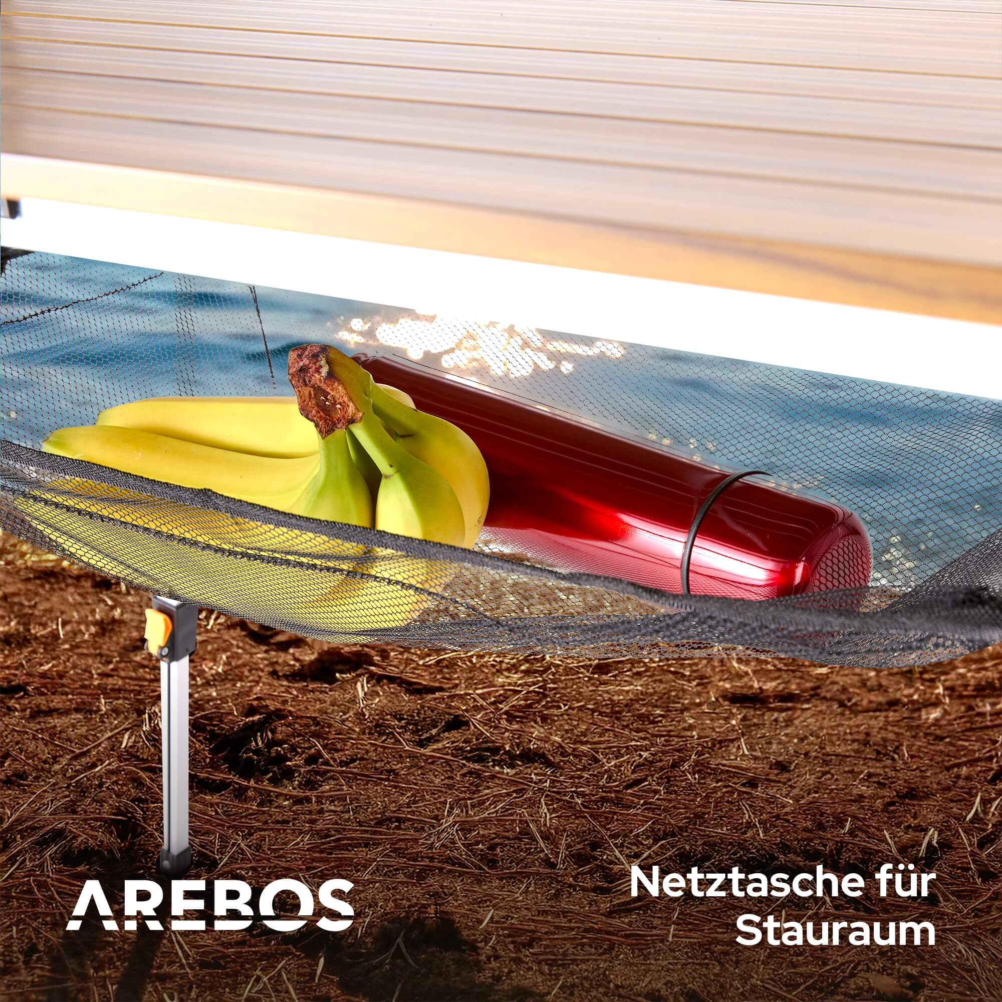 Nahaufnahme des Netzes eines Tisches. Bananen und eine rote Flasche sind darin, in der Nähe von Wasser.