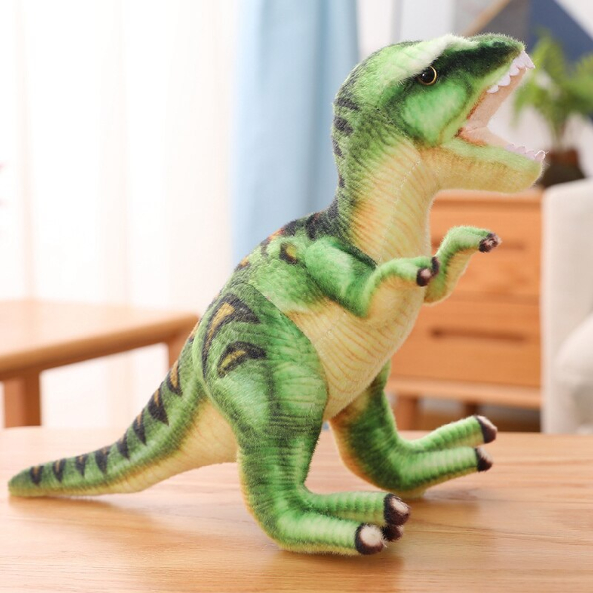 Grünes Dinosaurier-Plüschtier mit offenem Mund, auf einem Holztisch. Weißer Hintergrund.