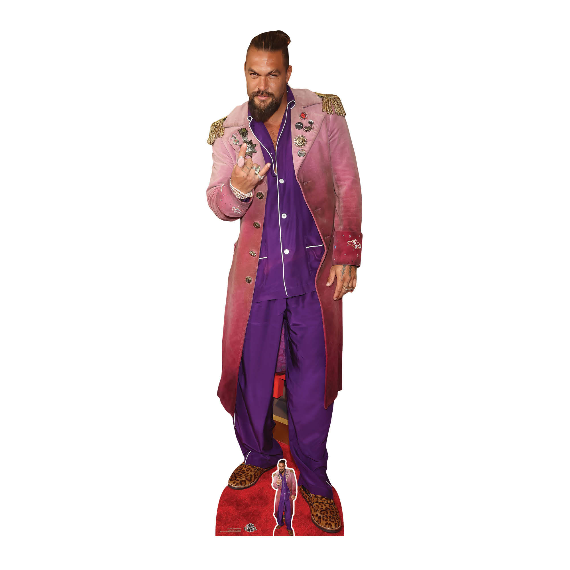 Ein Pappaufsteller von Jason Momoa. Er trägt einen rosa Mantel und einen lila Pyjama.