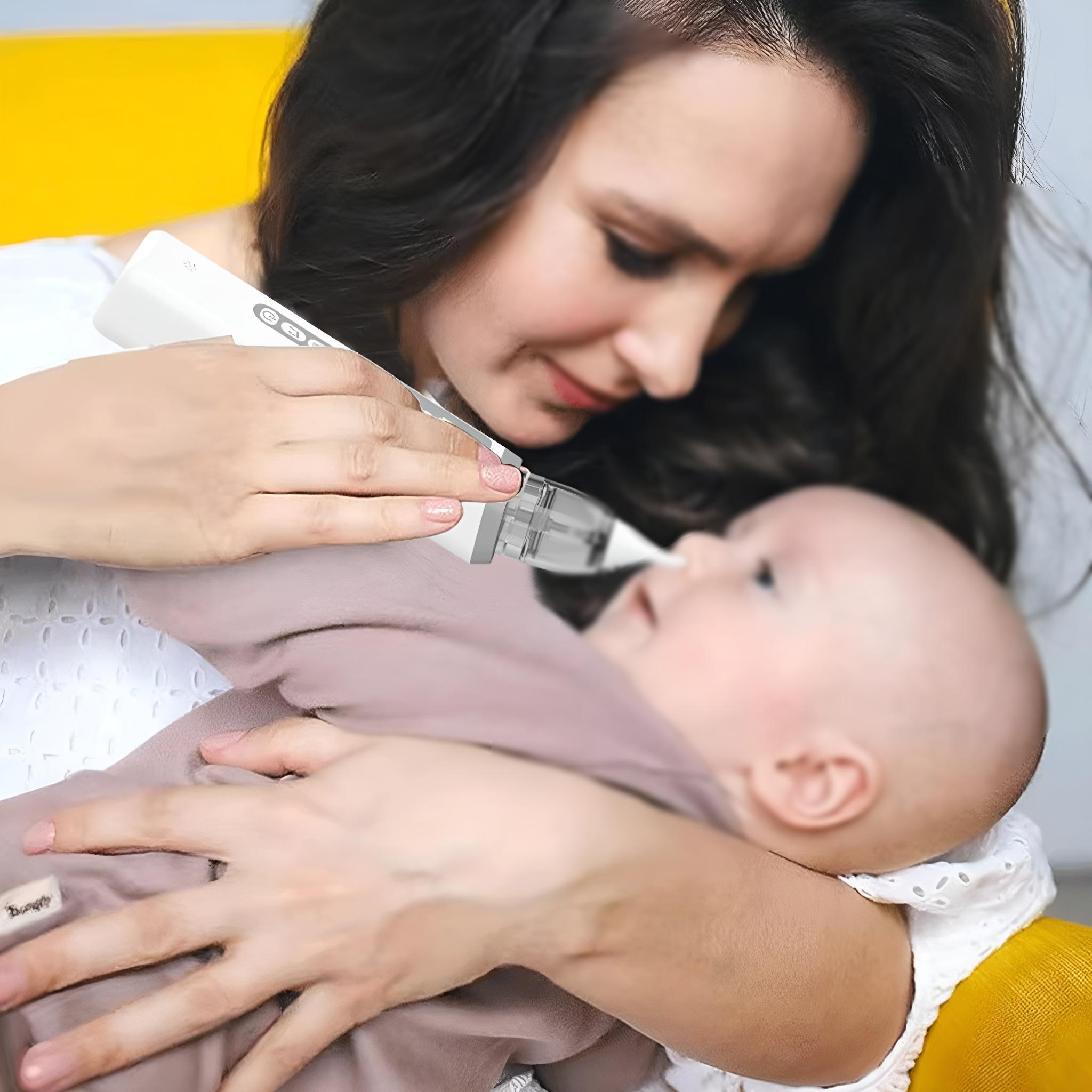 Eine Frau hält ein Baby, während sie einen Nasensauger am Baby verwendet.