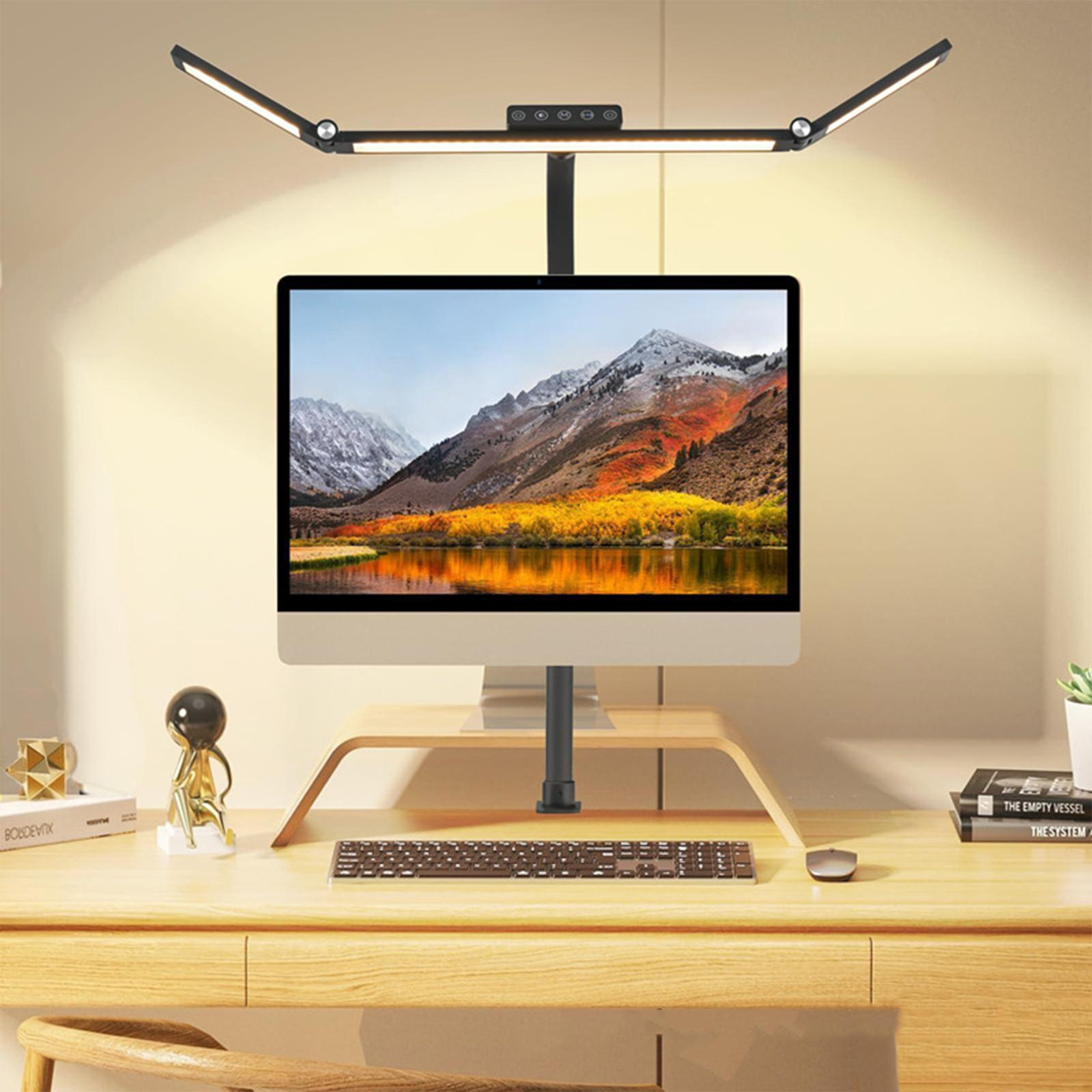 Schreibtisch mit Holzständer, Computermonitor, Tastatur, Maus und schwarzer Lampe mit zwei LED-Leuchten.