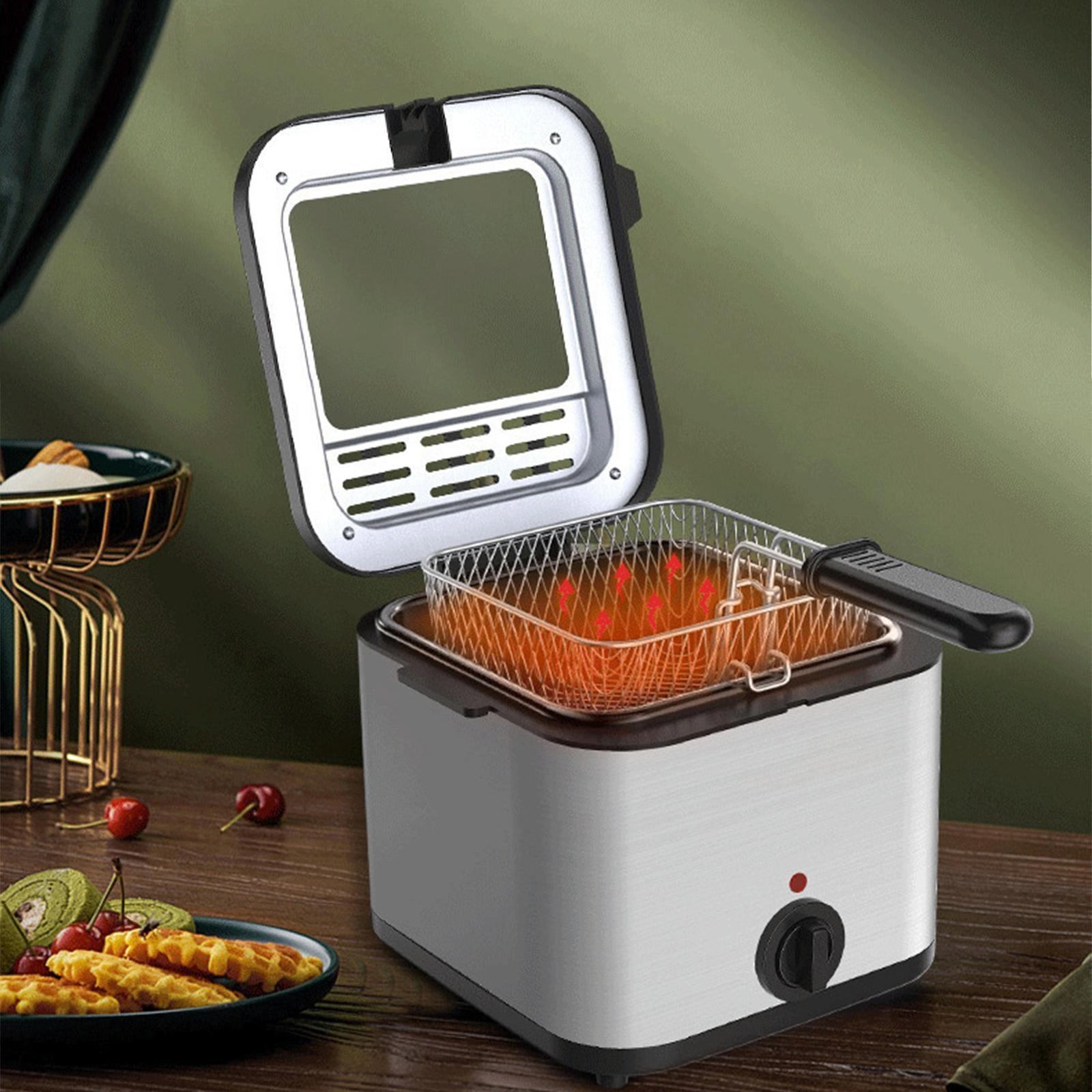 Eine Fritteuse mit roter Flüssigkeit, mit Waffeln und Kirschen daneben.