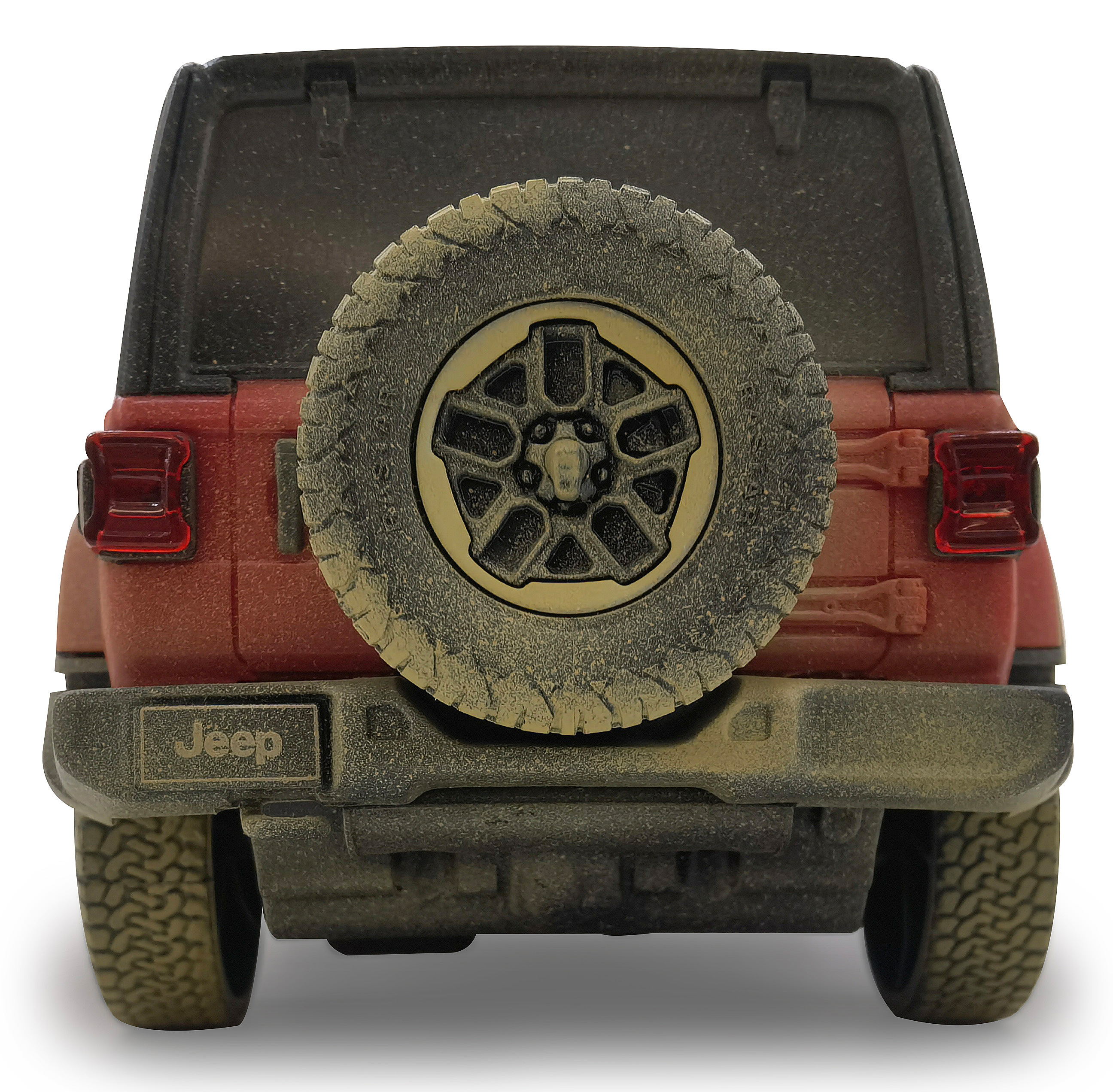 Die Rückseite eines roten Jeep Rubicon, bedeckt mit Schmutz. Ein Ersatzreifen ist montiert.