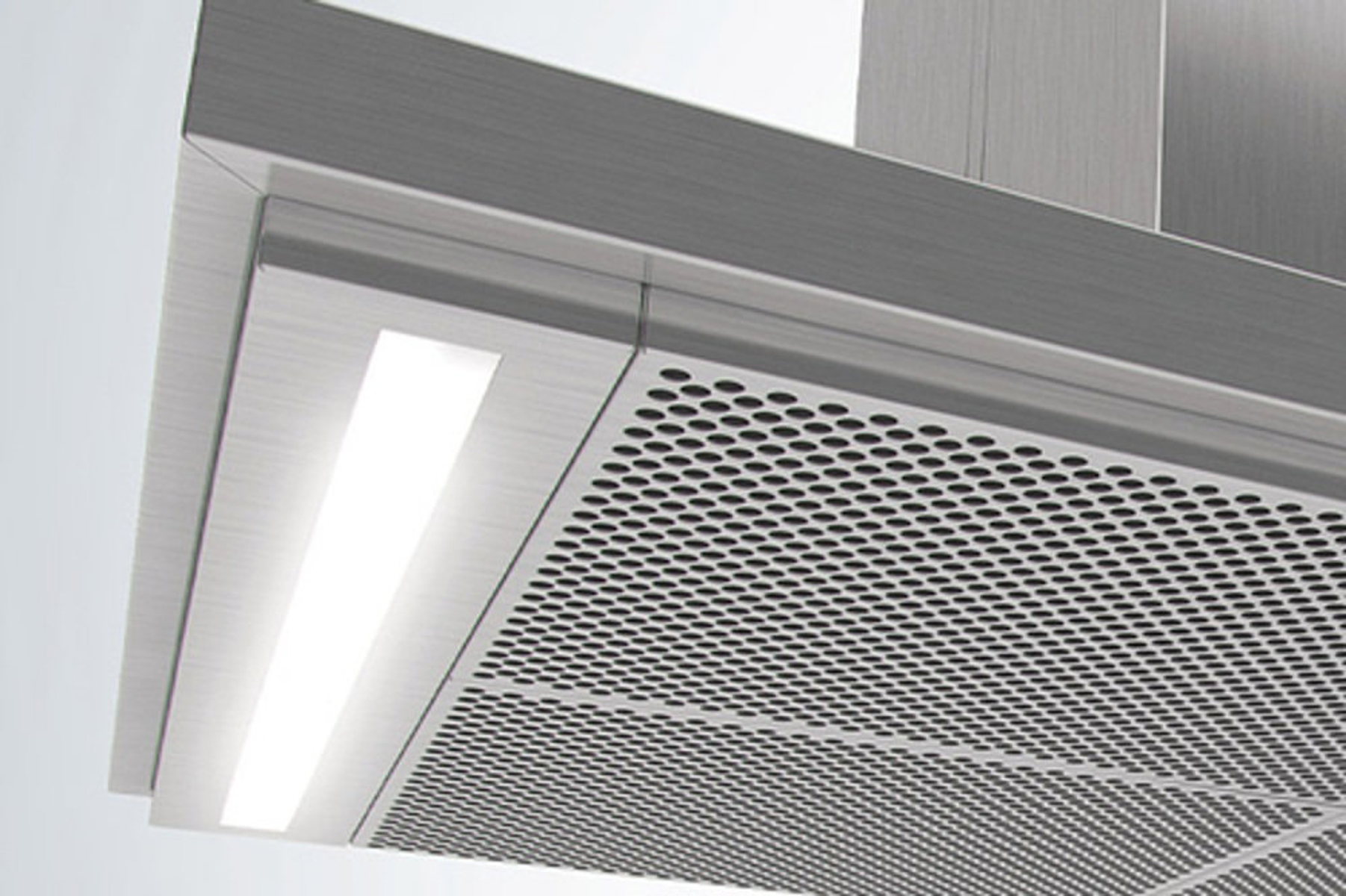Primo piano di una cappa in acciaio inossidabile con pannello in metallo perforato e luce LED brillante.