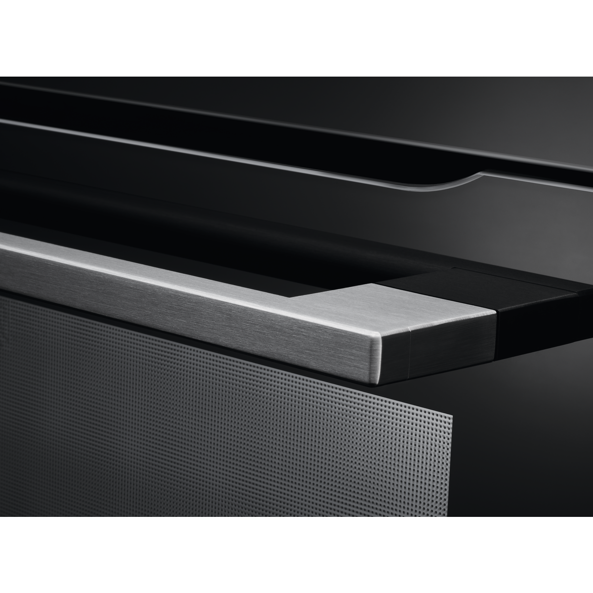 Primer plano de la puerta del horno y el panel de control, con superficie metálica perforada.