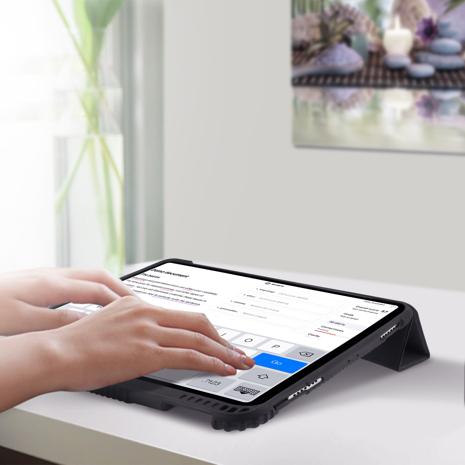 Mani che digitano su un tablet con custodia tastiera, su un tavolo bianco.