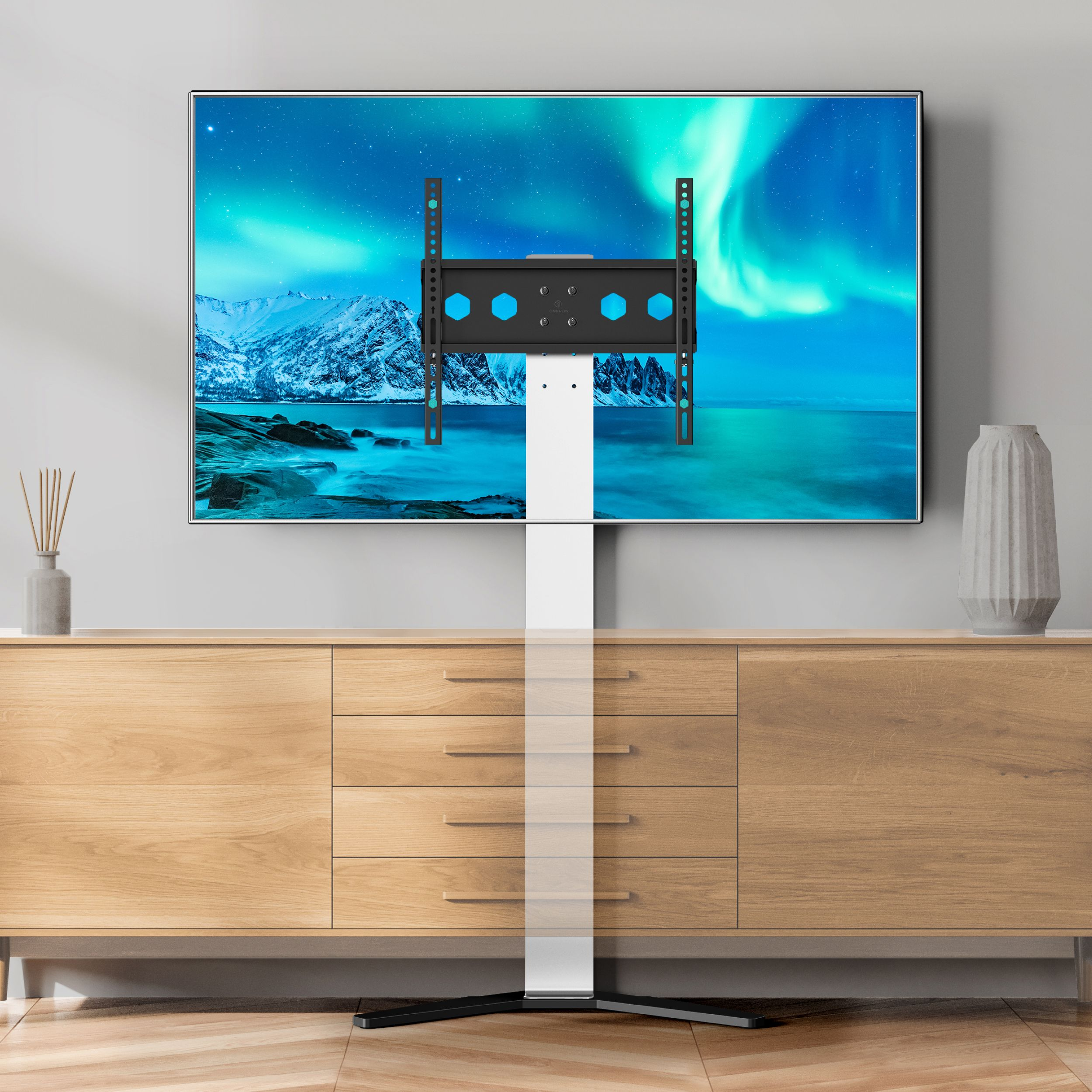 Telewizor na drewnianej szafce, zamontowany na stojaku. Tło: zaśnieżona góra, zorza polarna.