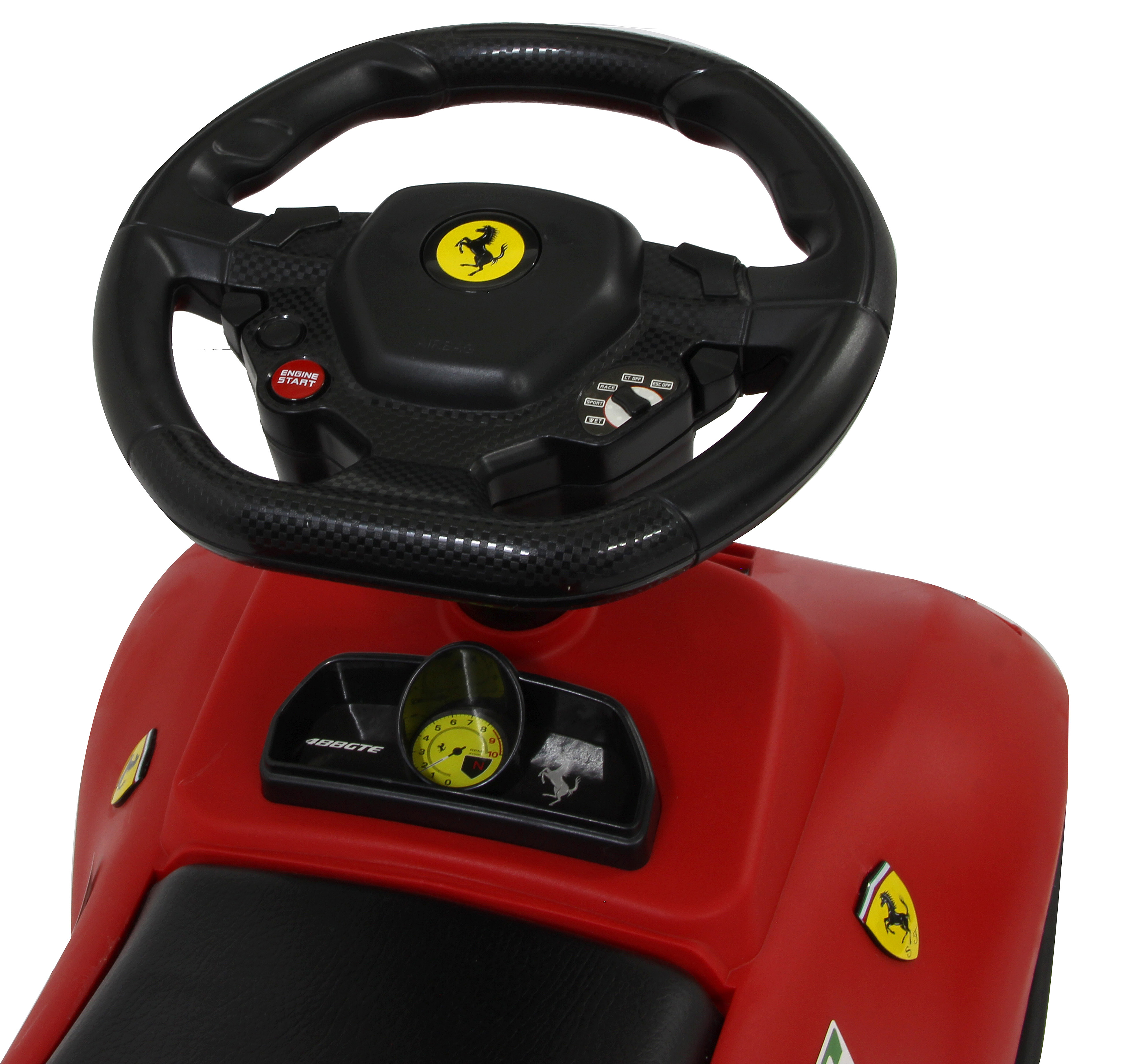 Primer plano del volante de un coche de juguete Ferrari rojo. Logotipo de Ferrari y detalles del salpicadero visibles.