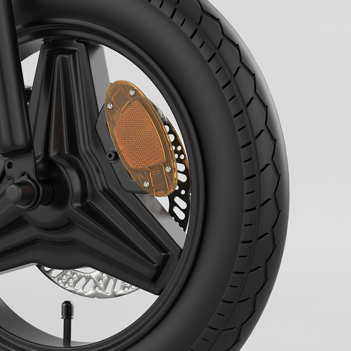 Zbliżenie koła roweru z czarną oponą, hamulcem tarczowym i pomarańczowym odblaskiem.