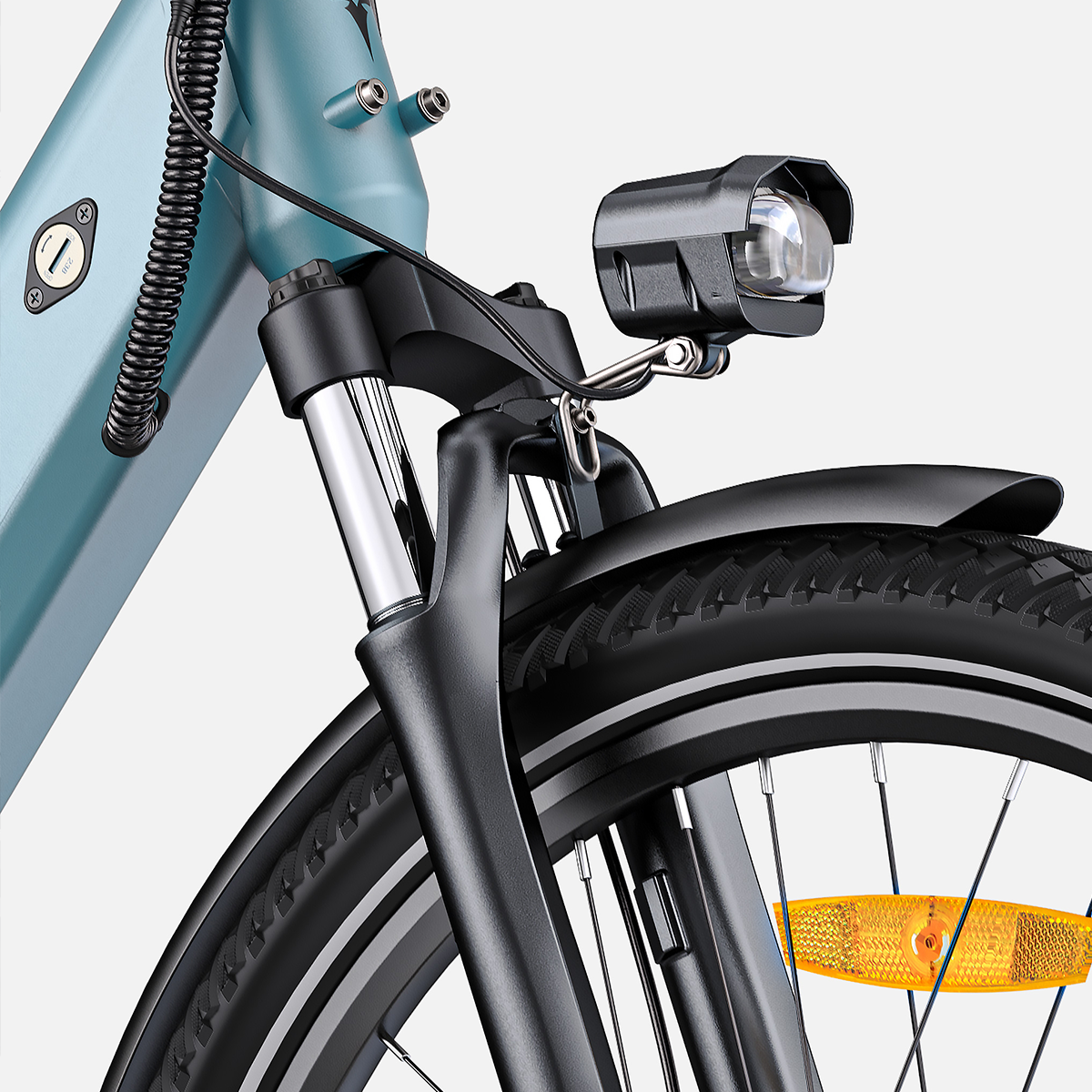Zbliżenie przedniej części niebieskiego roweru elektrycznego. Widoczny reflektor, błotnik i opona.