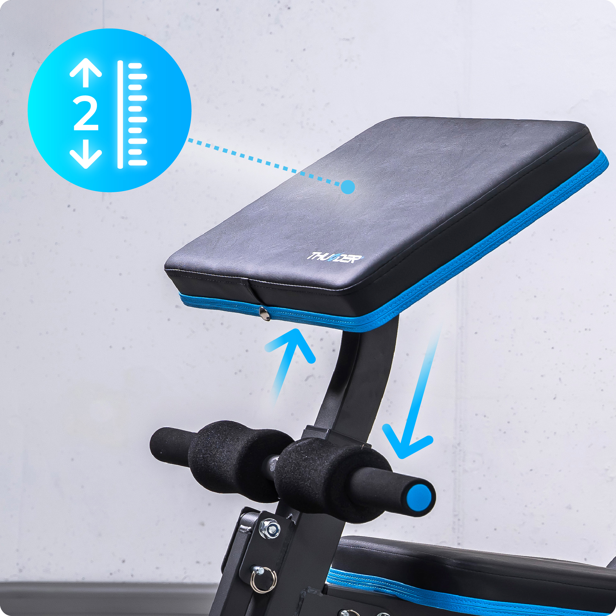 Zbliżenie na ławkę do ćwiczeń; strzałka pokazuje zakres ruchu regulowanego oparcia.